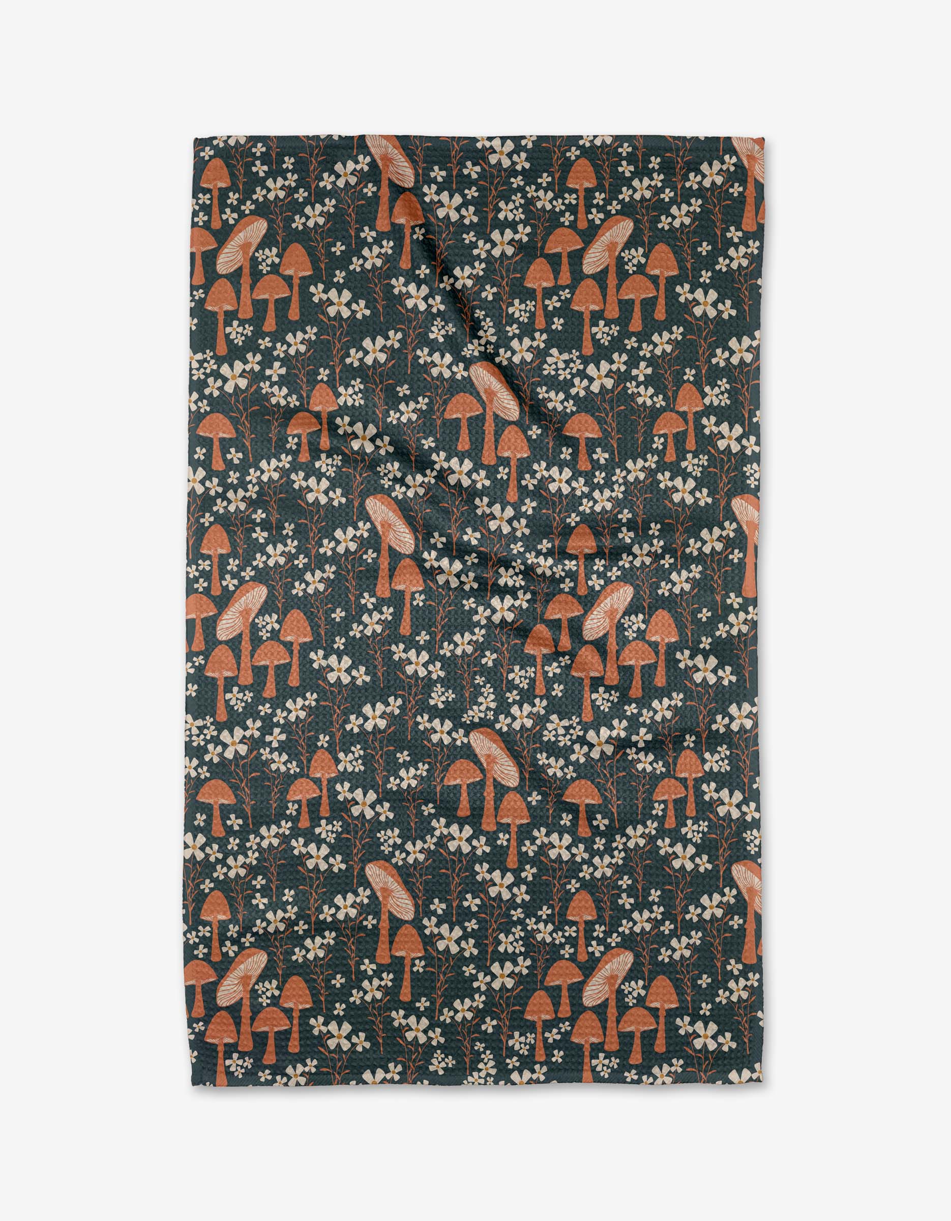 The Mushroom Grove by Charlie Rowan Designs is a rectangular, ultra-absorbent Geoweave fabric with a dark background, adorned with orange mushrooms and small white flowers. The fabric appears slightly wrinkled and is laid flat.