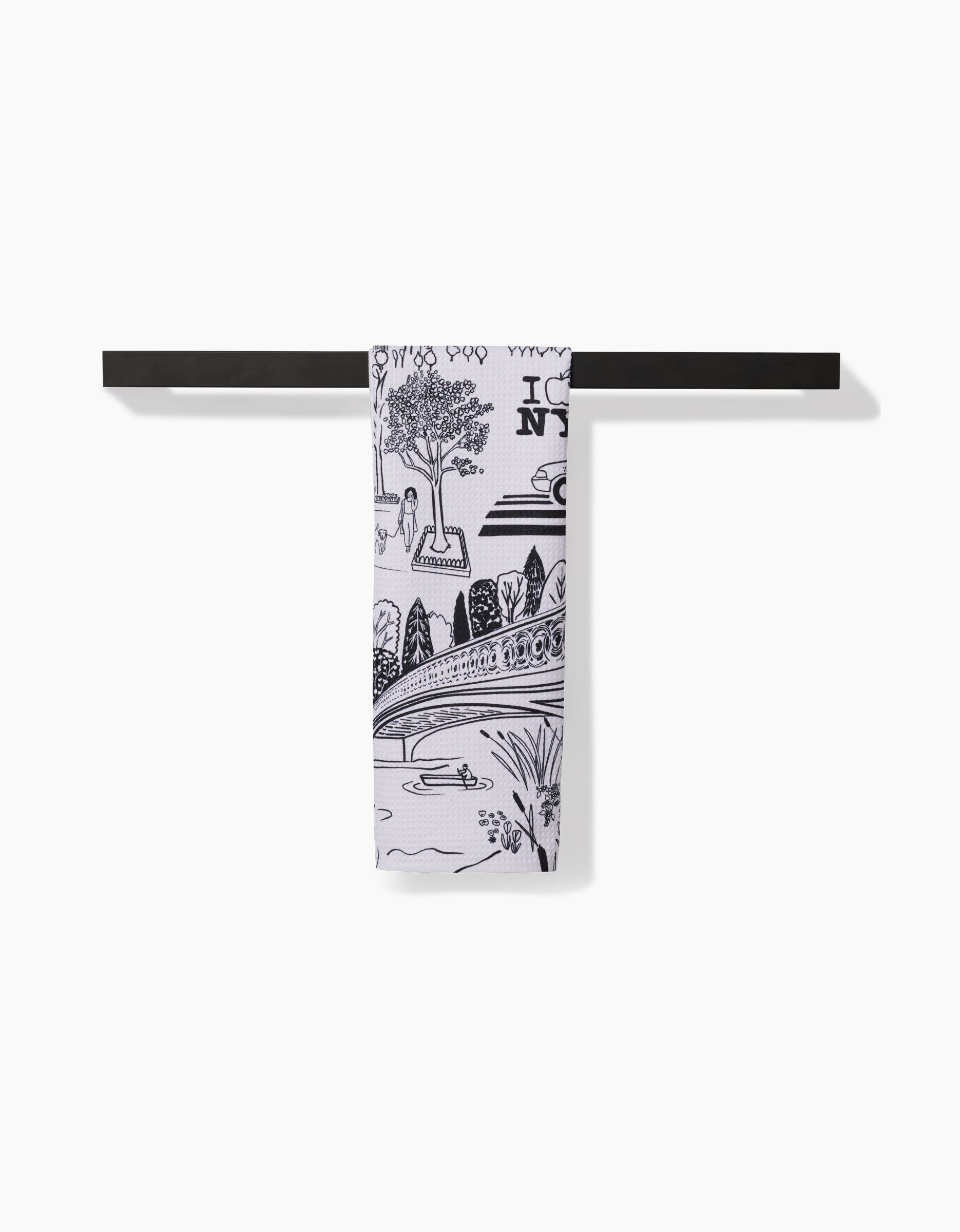 The Elisabeth Wing New York towel, featuring a black and white NYC scene on ultra-absorbent Geoweave fabric, is neatly folded over a simple black bar with a plain white background.