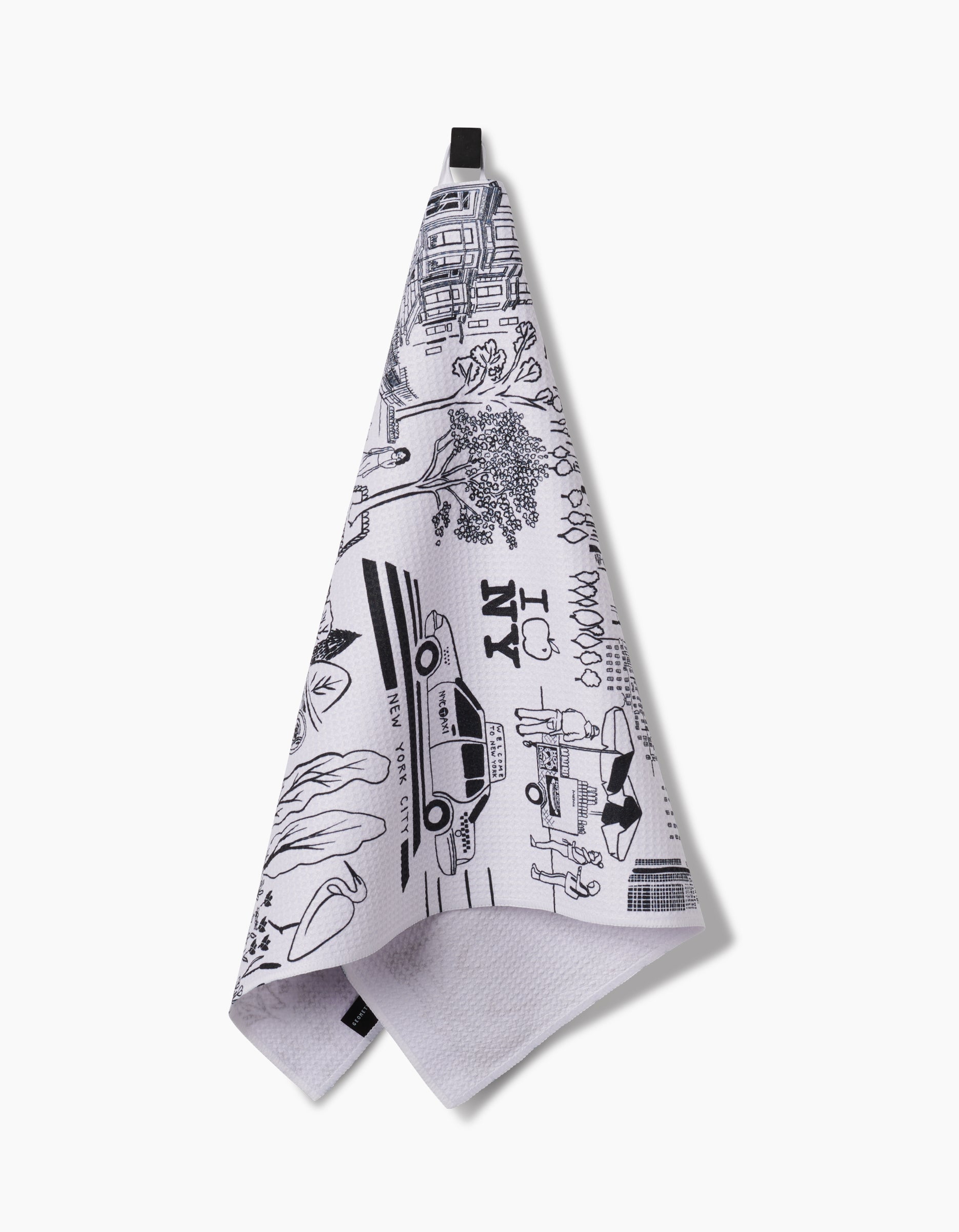 The Elisabeth Wing New York kitchen towel features ultra-absorbent Geoweave fabric and black line drawings of NYC icons like a taxi and “I ♥ NY”; it hangs from a black loop against a white background.