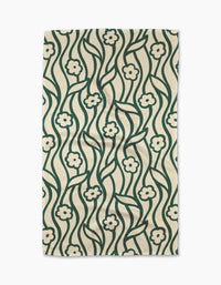 The Gerdadzy Nostalgic Flowers tea towel is rectangular and beige, featuring a green floral pattern with wavy stems and stylized flowers.