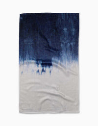 The Geometry Ocean Splash Tea Towel showcases a textured Geoweave fabric with an abstract, paint-like gradient design that transitions from deep navy blue at the top to white at the bottom, featuring visible creases.