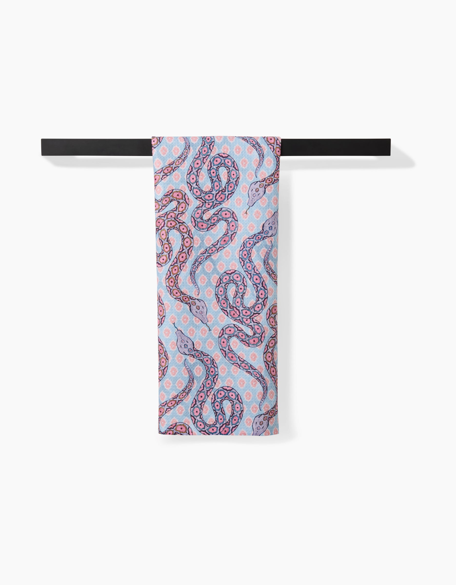 A light blue, ultra-absorbent Maayan Alper-Swan Ophidia tea towel featuring a vibrant pink and purple octopus pattern hangs neatly on a black rod against a white background.