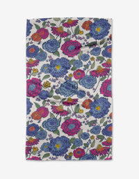 The Kris Ruff Painterly Meadow towel is a rectangular, ultra-absorbent white towel with a colorful floral pattern of large blue, pink, yellow, and purple flowers plus green leaves scattered across the surface.