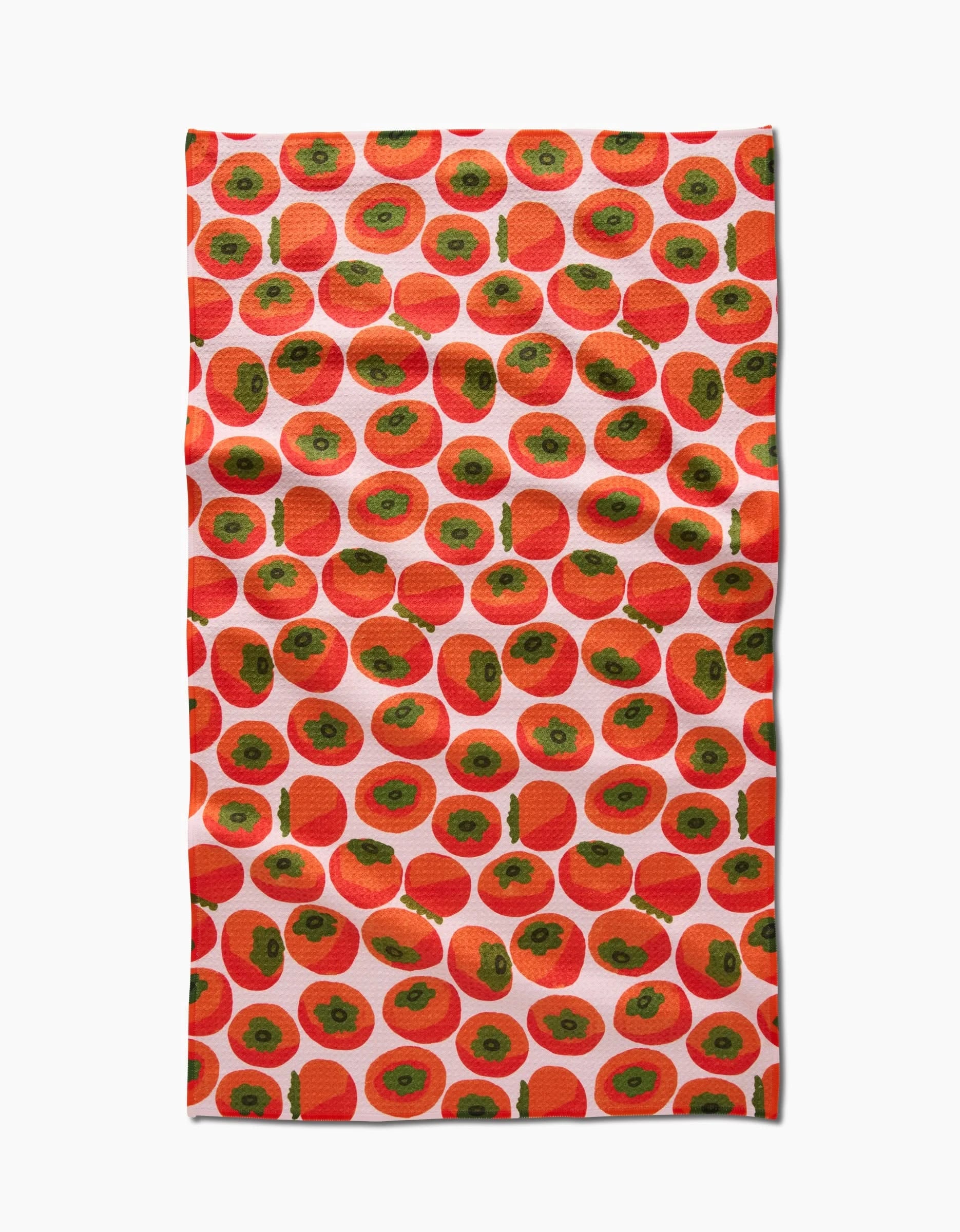A rectangular kitchen tea towel by Katie OShea, called Persimmons, made from Geoweave fabric and featuring a vibrant, playful design of evenly spaced red and green persimmons on a white background.