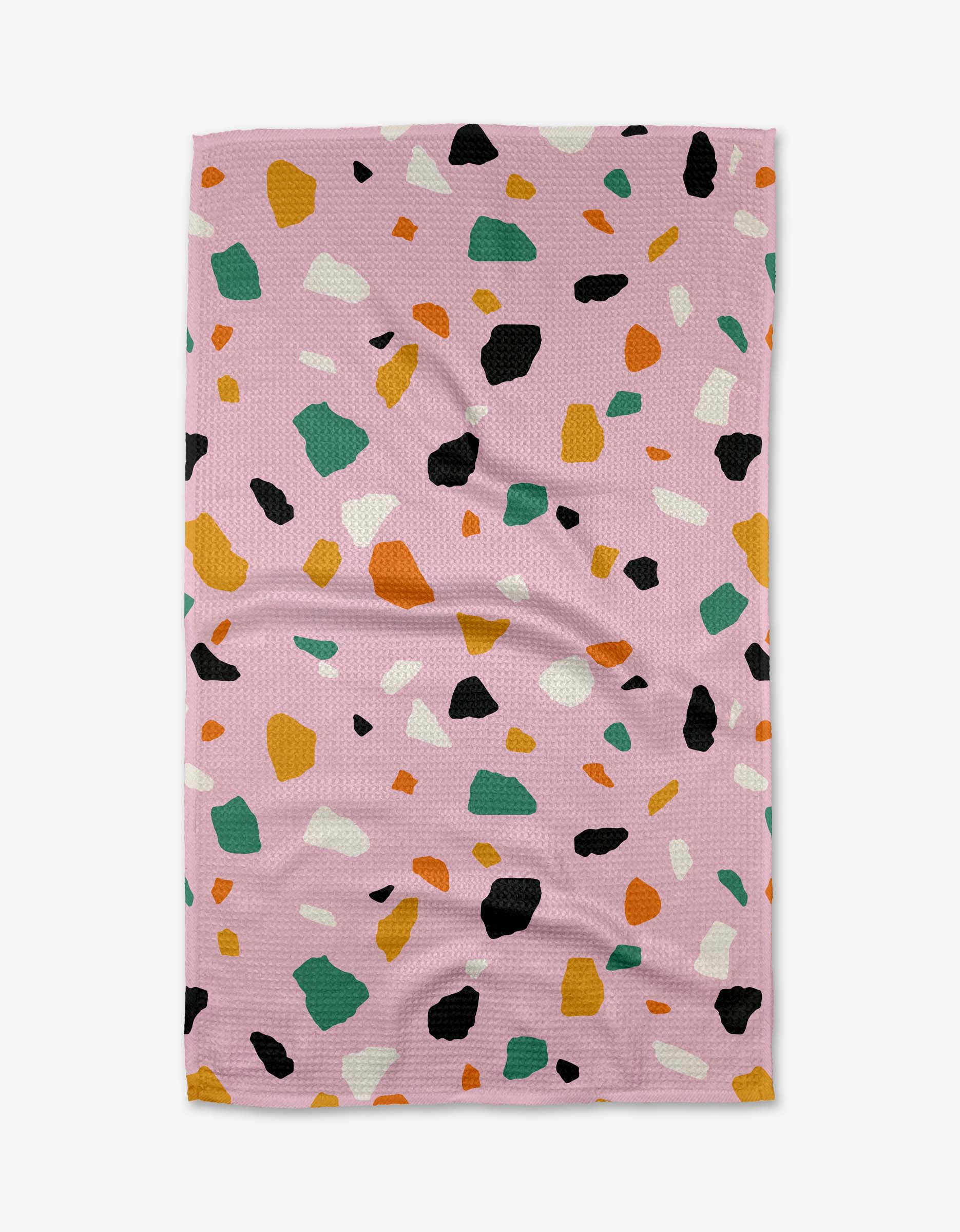 The Pink Terrazzo tea towel by Megan Roy is crafted from recycled geoweave fabric and features a pink rectangular design with a terrazzo pattern of green, orange, white, black, and yellow irregular shapes.