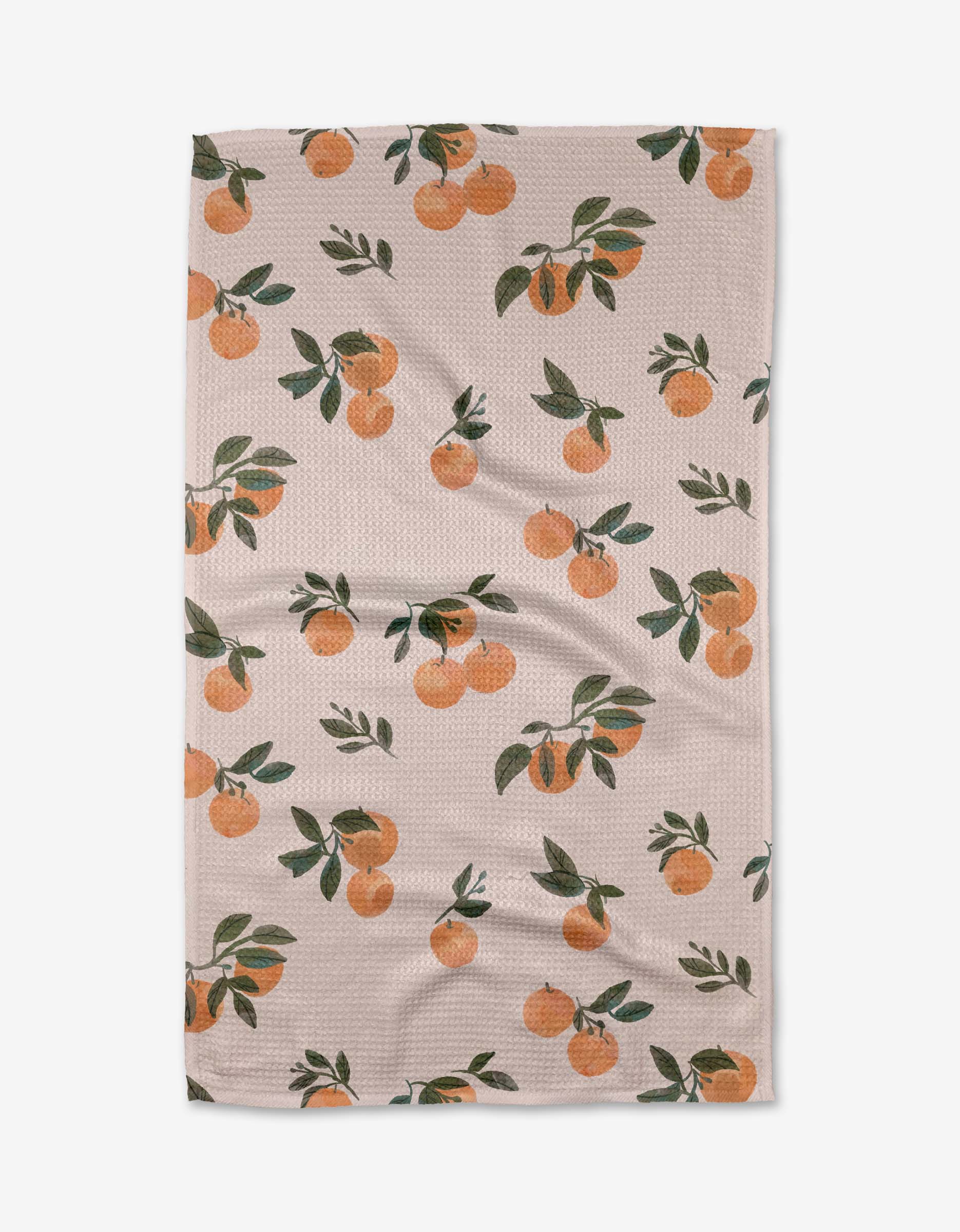 The Pretty In Peach tea towel by Janna Sue Design features illustrated oranges with green leaves on ultra-absorbent, textured beige fabric. Shown slightly wrinkled against a white background.