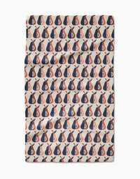 The Retro Pears tea towel by Megan Kampa is beige and features a repeating pattern of red, navy, and white abstract shapes in neat rows and columns.