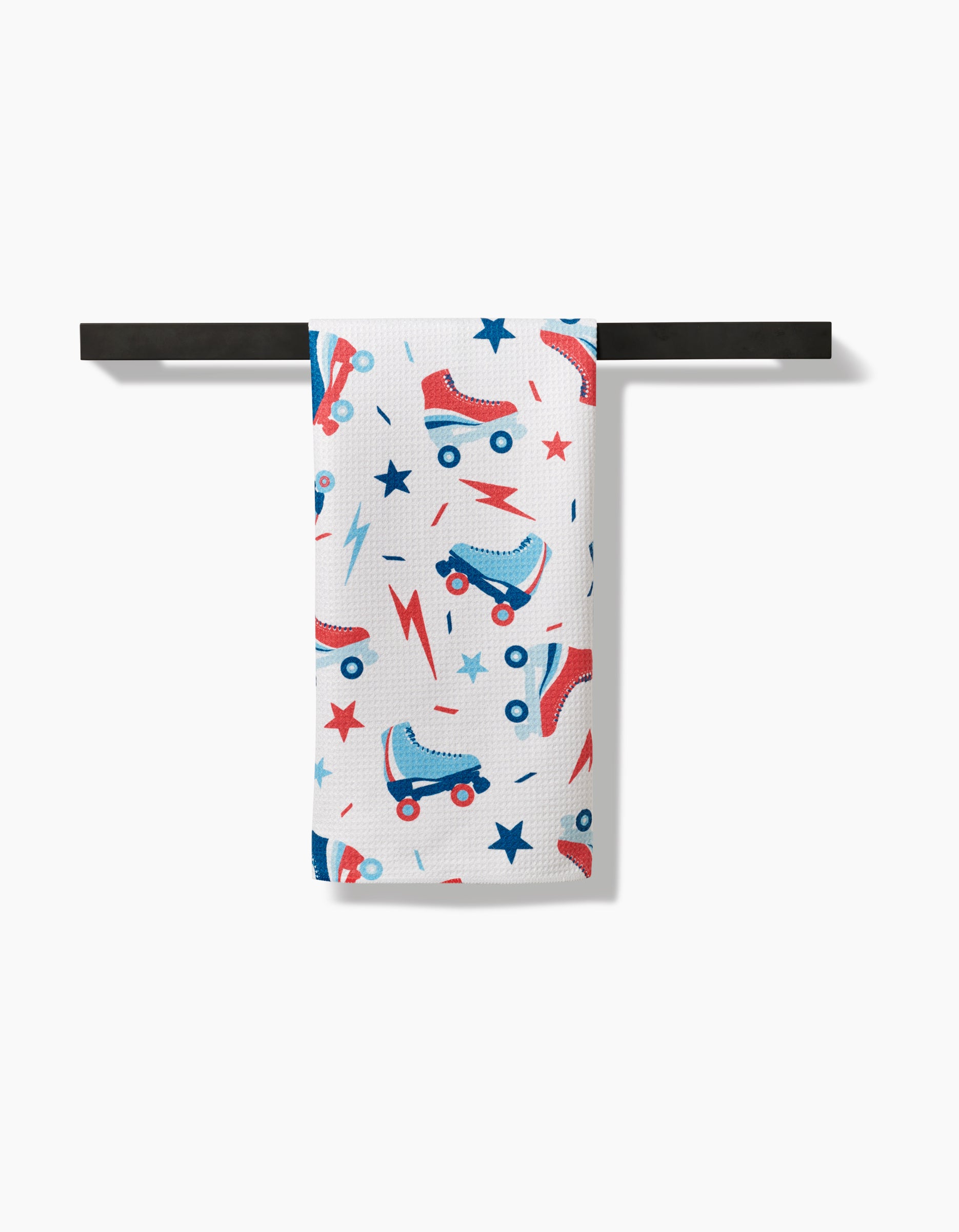 The Rolling With Stars towel by Hufton Studio features a fun print of red and blue roller skates, stars, and lightning bolts on white Geoweave fabric, offering ultra-absorbency and fast drying on any towel bar.