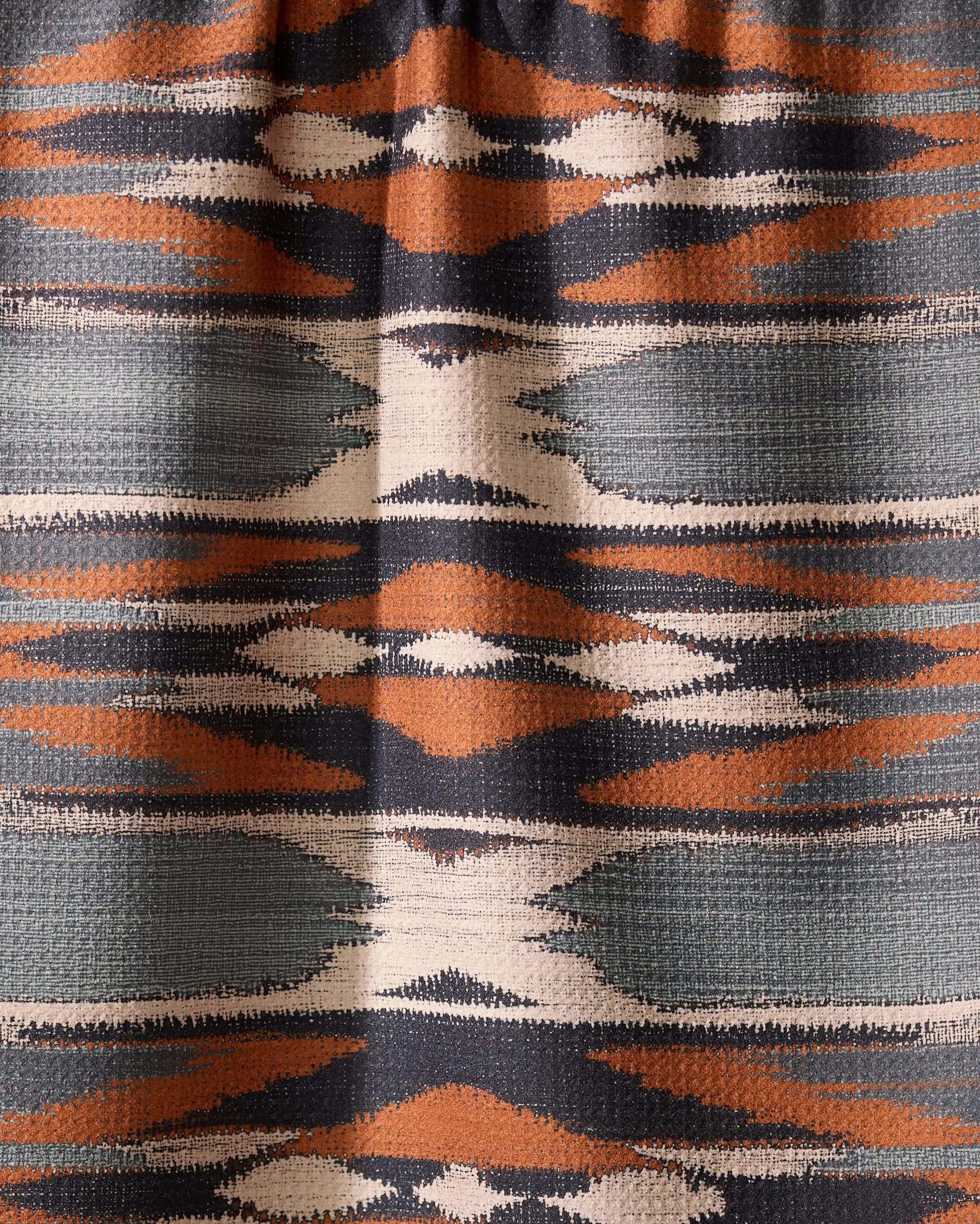 The Geometry Sedona tea towel features a geometric textile pattern with horizontal bands in orange, navy, white, and gray, showcasing symmetrical diamonds and zigzags—perfect for brightening your kitchen with its quick-drying design.