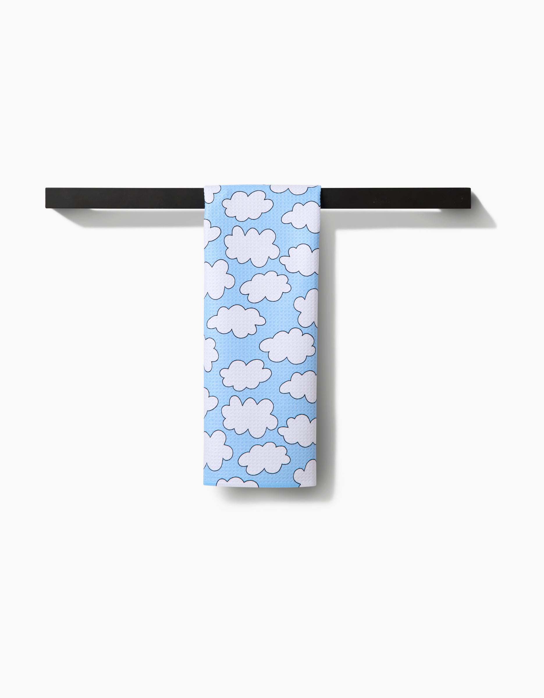 The Mindfulnice Silver Linings towel, featuring a white cloud pattern on light blue ultra-absorbent Geoweave fabric, hangs neatly over a black bar against a plain white background.