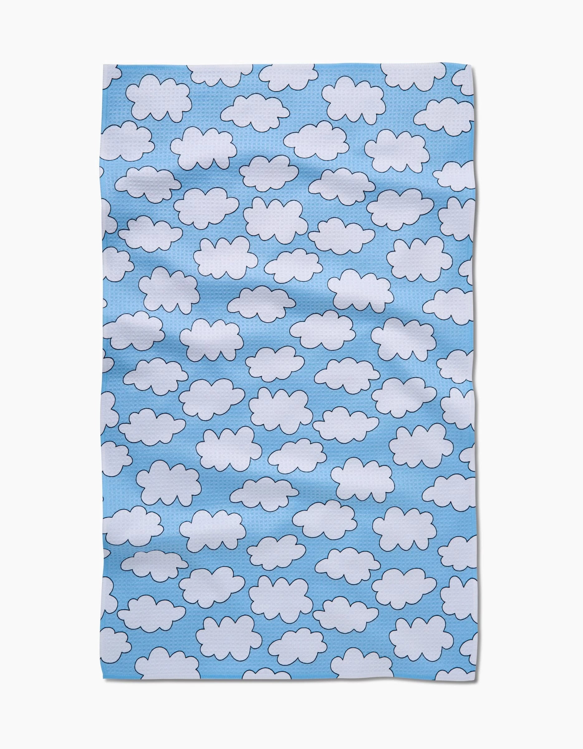 The Mindfulnice Silver Linings rectangular cloth showcases white cartoon clouds on a light blue background, crafted from eco-friendly, ultra-absorbent Geoweave fabric with a slightly wrinkled look.