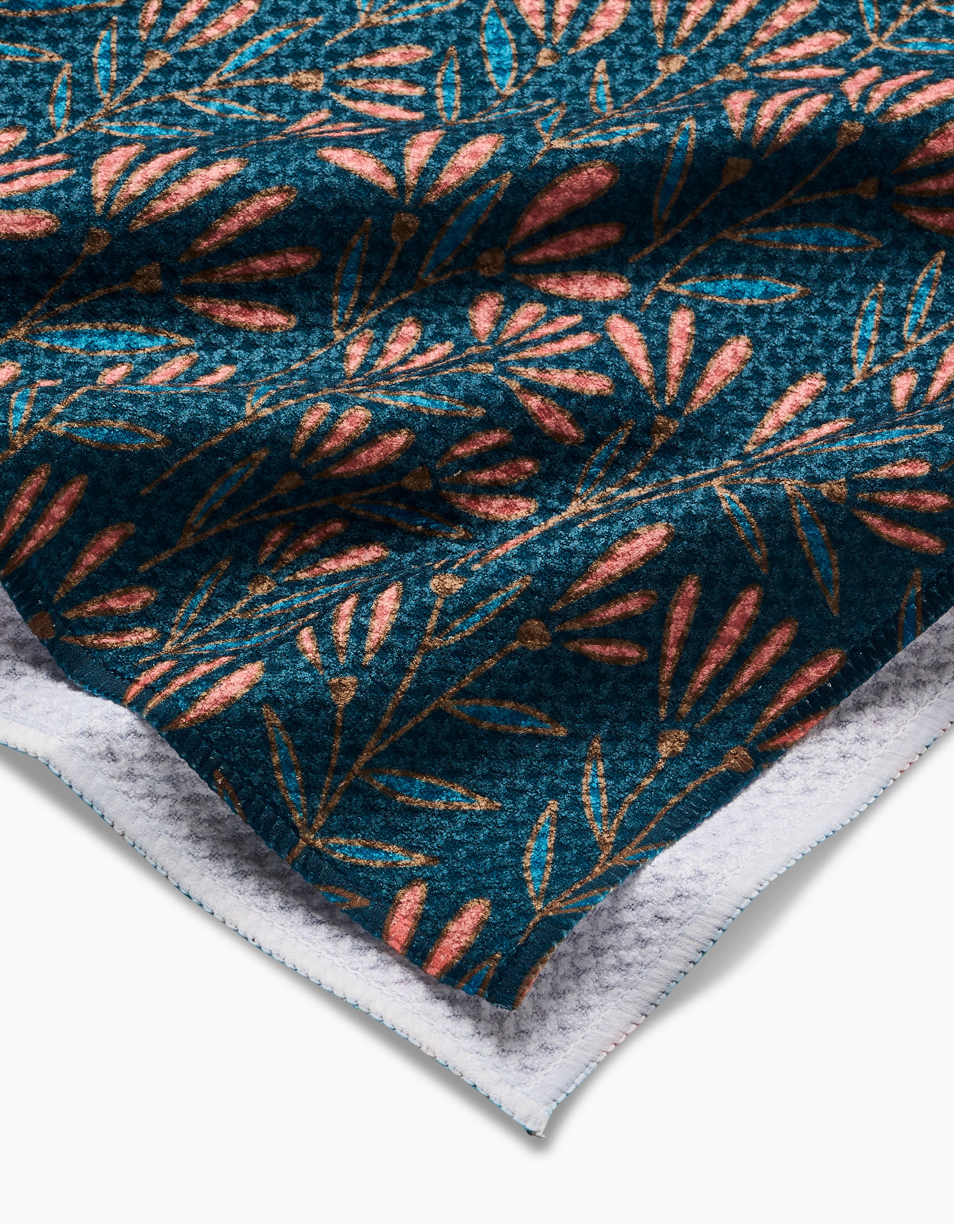 Sirocco by Amy MacCready is a tea towel made from Geoweave fabric, featuring a dark blue background with pink and gold leaves and branches, a soft white backing, ultra-absorbency, and a textured surface.