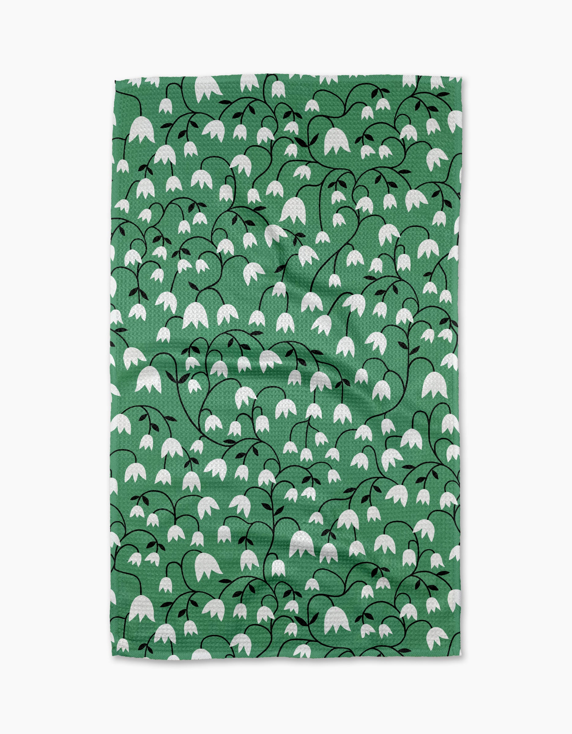 The Snowdrop tea towel by Rachel Parker is green and rectangular, featuring a repeating pattern of white, bell-shaped snowdrop flowers with black stems and leaves—an elegant and charming accent for any kitchen.