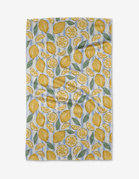 The Sour Lemon Stripes tea towel by Hufton Studio is an ultra-absorbent white kitchen towel featuring a repeating pattern of whole lemons, lemon slices, and green leaves scattered across its surface.