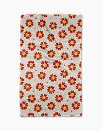 The Linda Fox Spotty Floral tea towel is beige and rectangular, with a repeating red and yellow flower pattern and small red dots. Made from quick-drying recycled materials, it’s shown laid flat with subtle wrinkles.