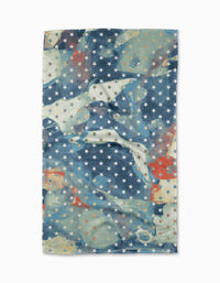 The Geometry Starry Dreams Tea Towel features Geoweave fabric with a blue, white, and red mottled design accented by a grid of small white stars.