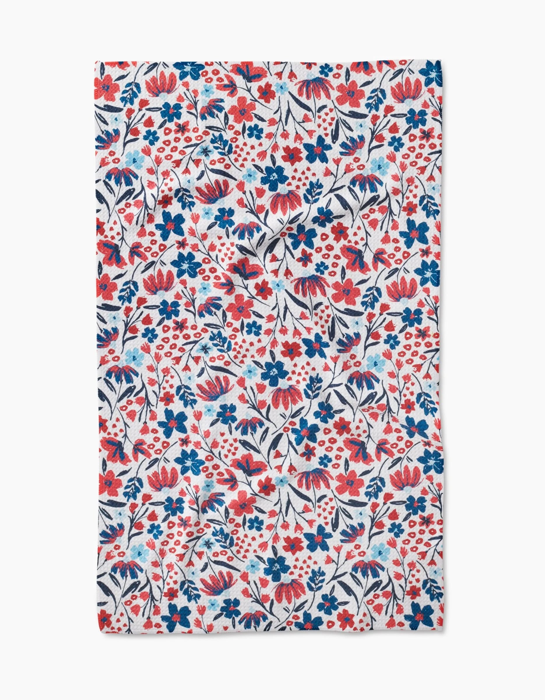 The Summer Bloom tea towel by Hufton Studio is made from Geoweave fabric and features a lively, dense floral pattern with red, blue, and navy flowers and leaves on a white background.