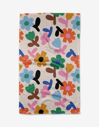 The Sunny Bloom tea towel by Jennifer Bouron features a colorful, abstract floral pattern in green, blue, orange, pink, red, black, and yellow on white. Made from ultra-absorbent recycled materials.