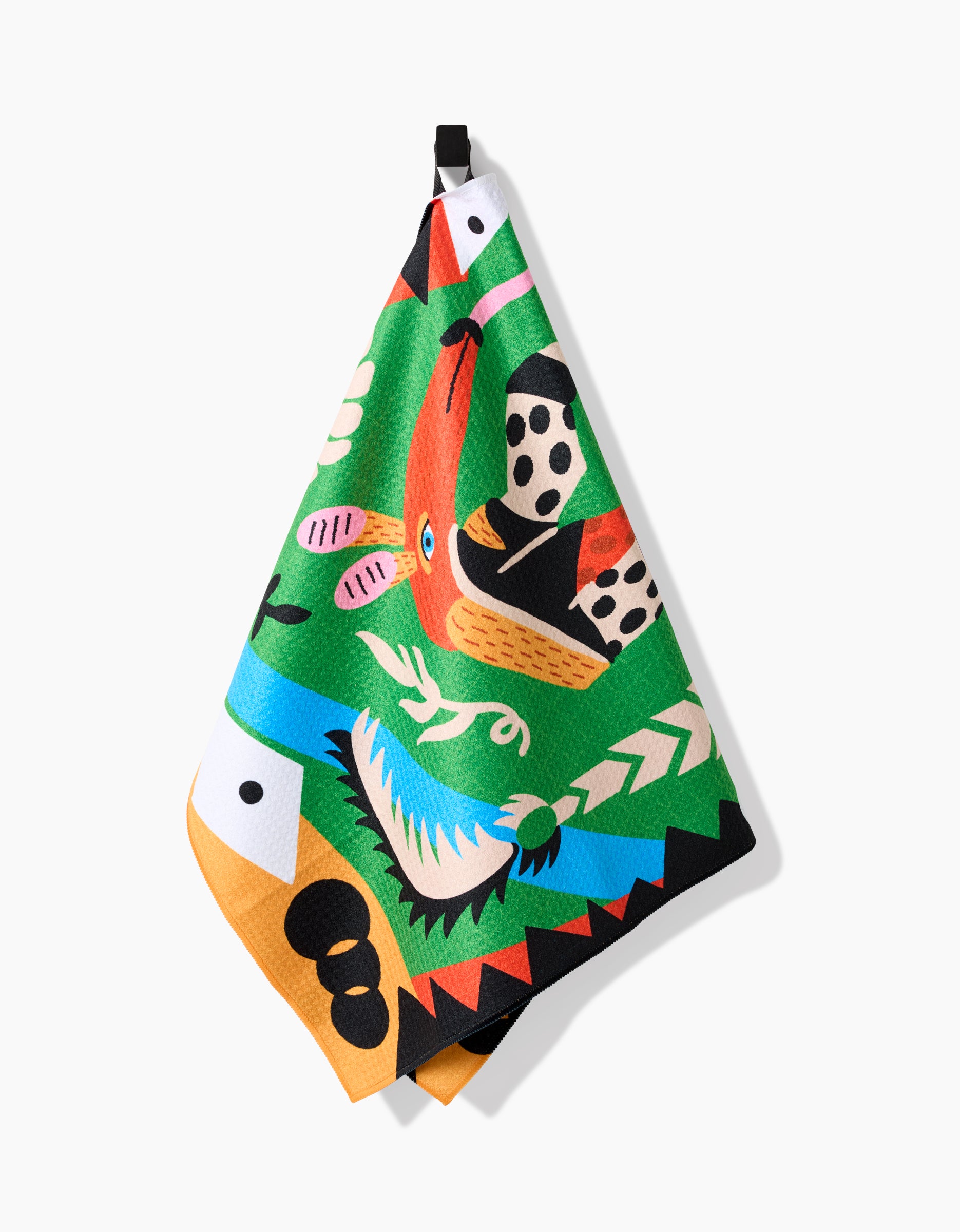 The Tamanduá Bandeira tea towel by Camila Leão features a bold, abstract bird design in green, red, orange, blue, black, and white on Geoweave Fabric. It hangs from a black loop against a white background.