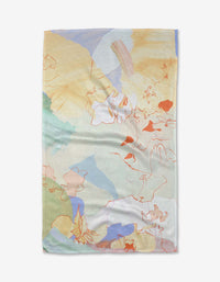 The Tree House tea towel by Kristina Baker is rectangular, made from recycled materials, and features an abstract design with pastel yellow, blue, green, and peach shapes plus thin red lines on a light background for a modern look.