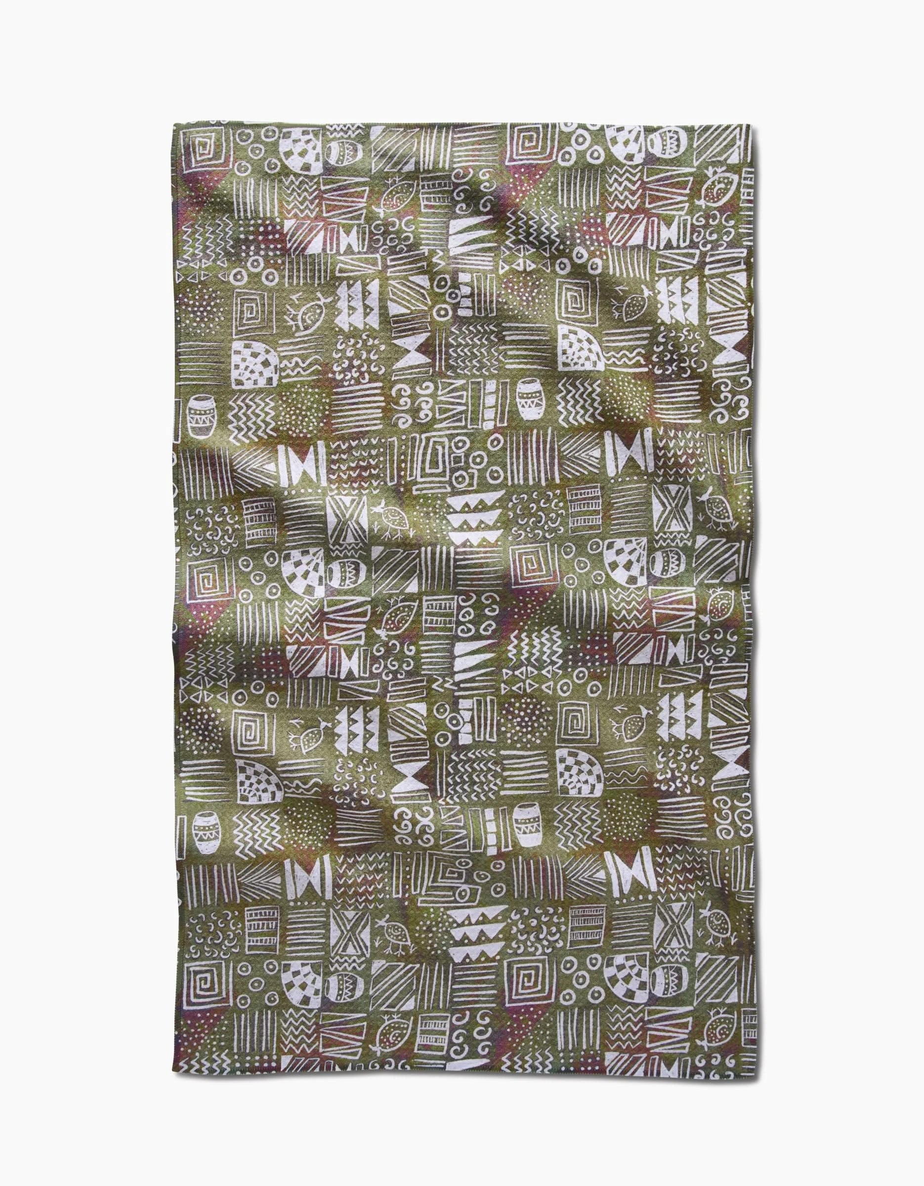 The Taryn Brennan Tribal Symbols tea towel is a rectangular Geoweave fabric with a green background, displaying white hand-drawn geometric and abstract patterns in squares, and is crafted from recycled materials.