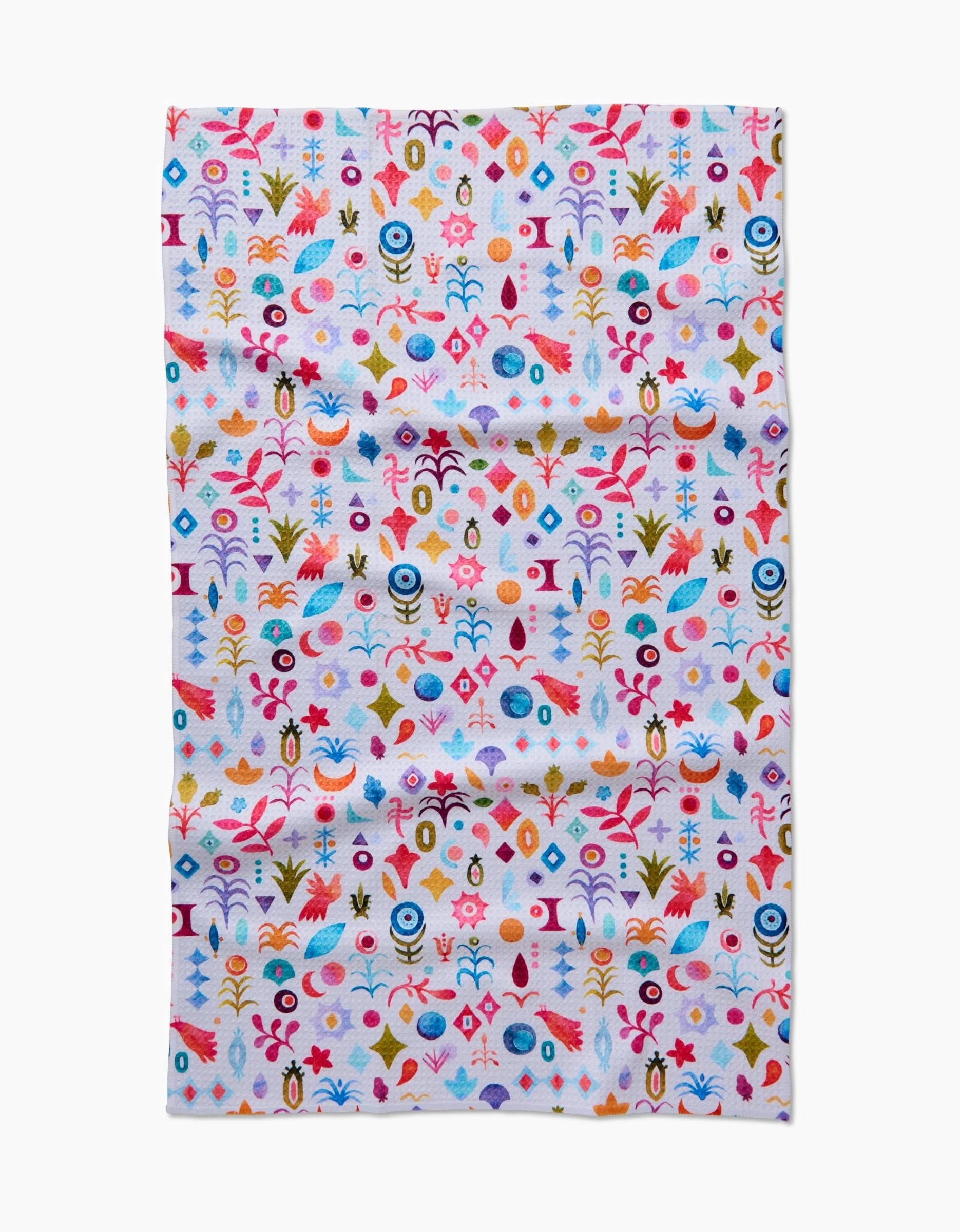 The Tula Tea Towel by Maayan Alper-Swan showcases a vibrant abstract floral and geometric pattern in red, blue, yellow, orange, and pink on white Geoweave fabric that is soft and eco-friendly.