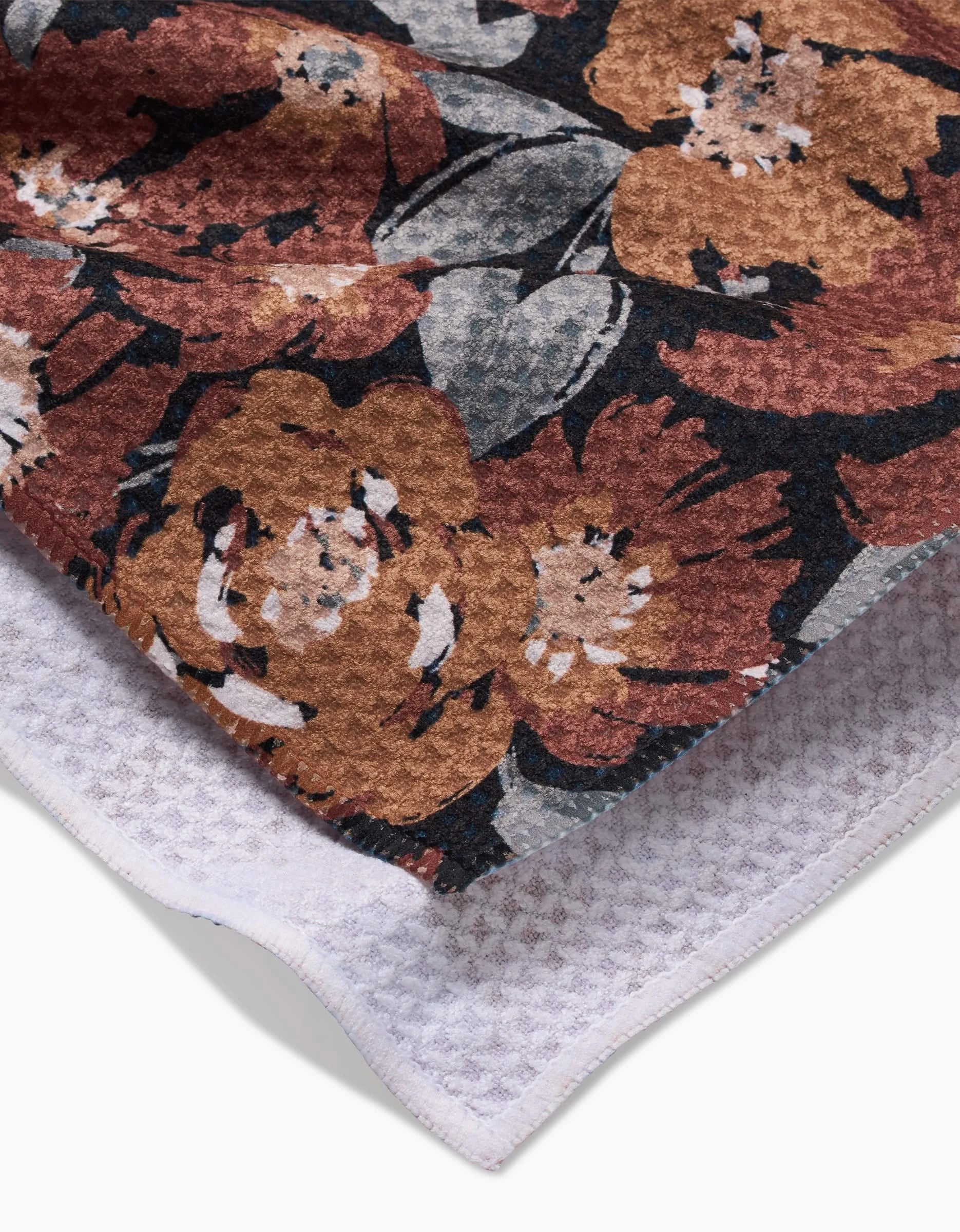 A close-up of Hufton Studios Vintage Floral Natural towel, showcasing a brown, orange, and gray floral pattern on one side with ultra-absorbent white Geoweave fabric on the reverse.