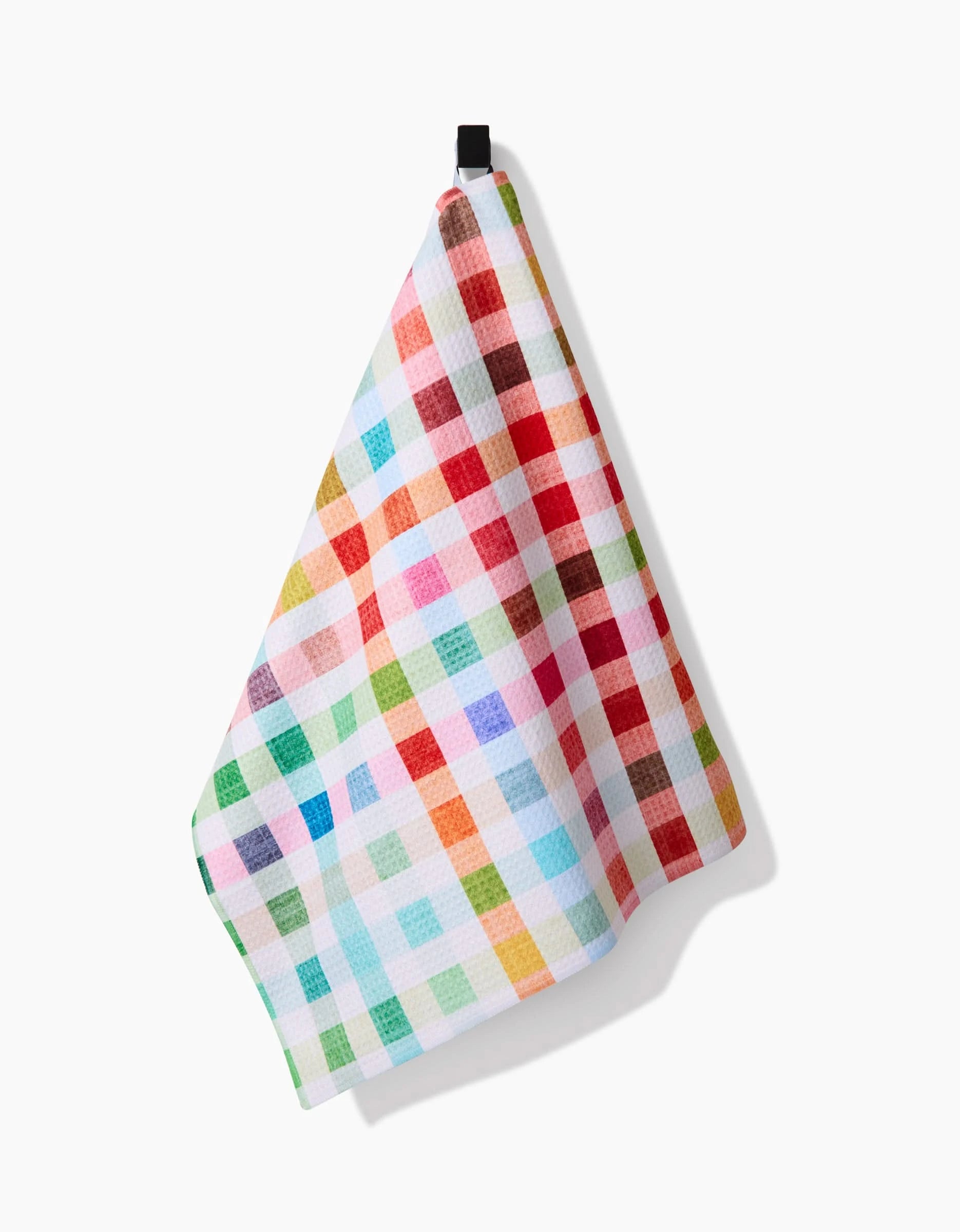 The Pascale Dilger Woven Spring Plaid dish towel, featuring a vibrant checkered pattern in red, blue, green, yellow, and orange, hangs from a black loop. Made with ultra-absorbent Geoweave fabric against a white background.