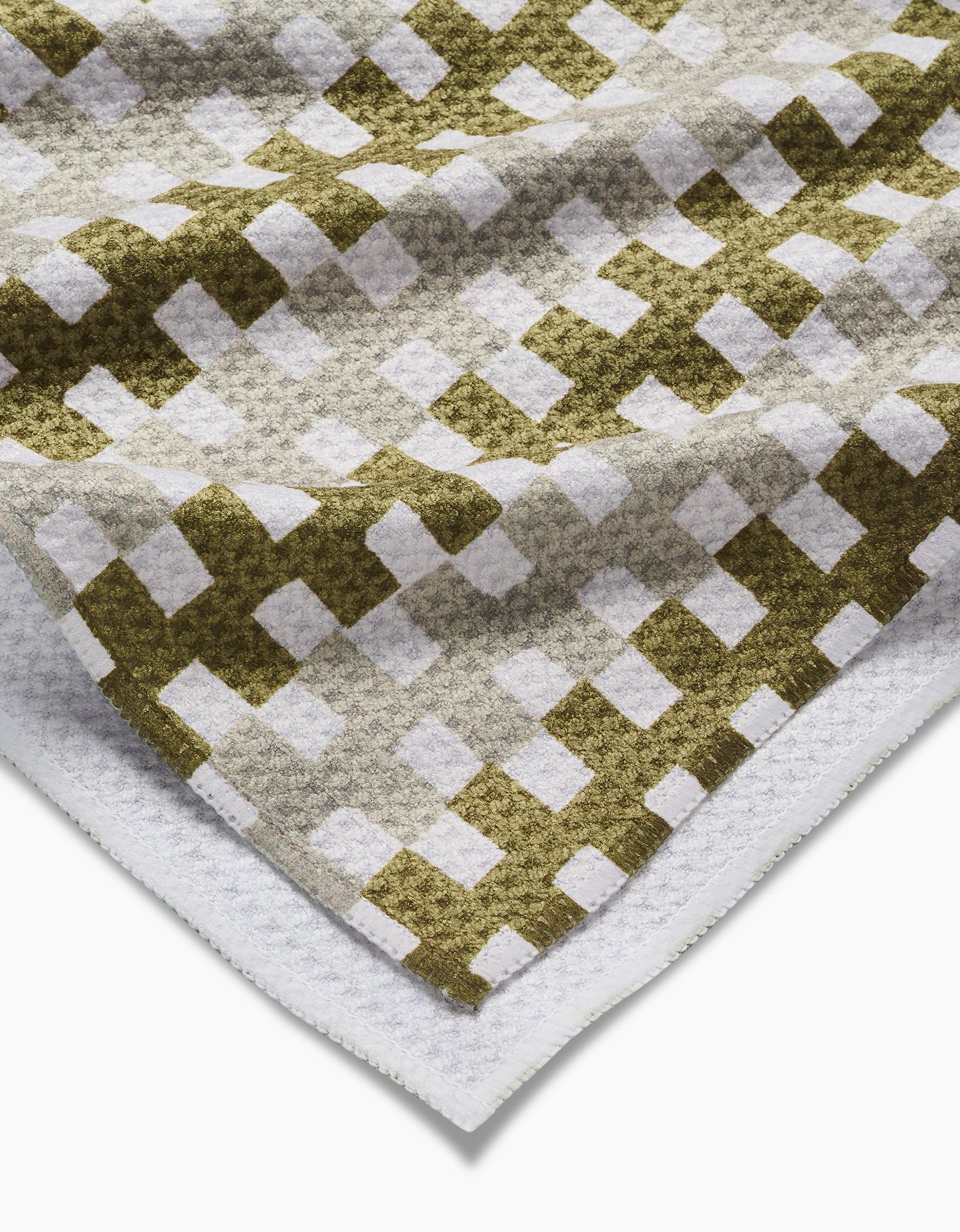 The Zippy dish towel by Studio Jeannot features a green and beige checkered pattern on white, with textured, ultra-absorbent fabric and visible folds and edges.