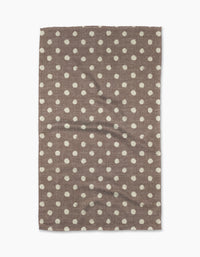 The Freckle Off White kitchen towel by Geometry features a rectangular eco-friendly fabric with an even white dot pattern. Slightly wrinkled and brown in color, it is displayed on a white background.