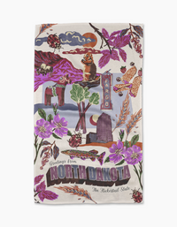 Geometry’s “Greetings From North Dakota” tea towel is illustrated with landmarks, purple flowers, ladybugs, a flickertail gopher, and a Fargo street sign. Made from recycled materials, it features “The Flickertail State” greeting.