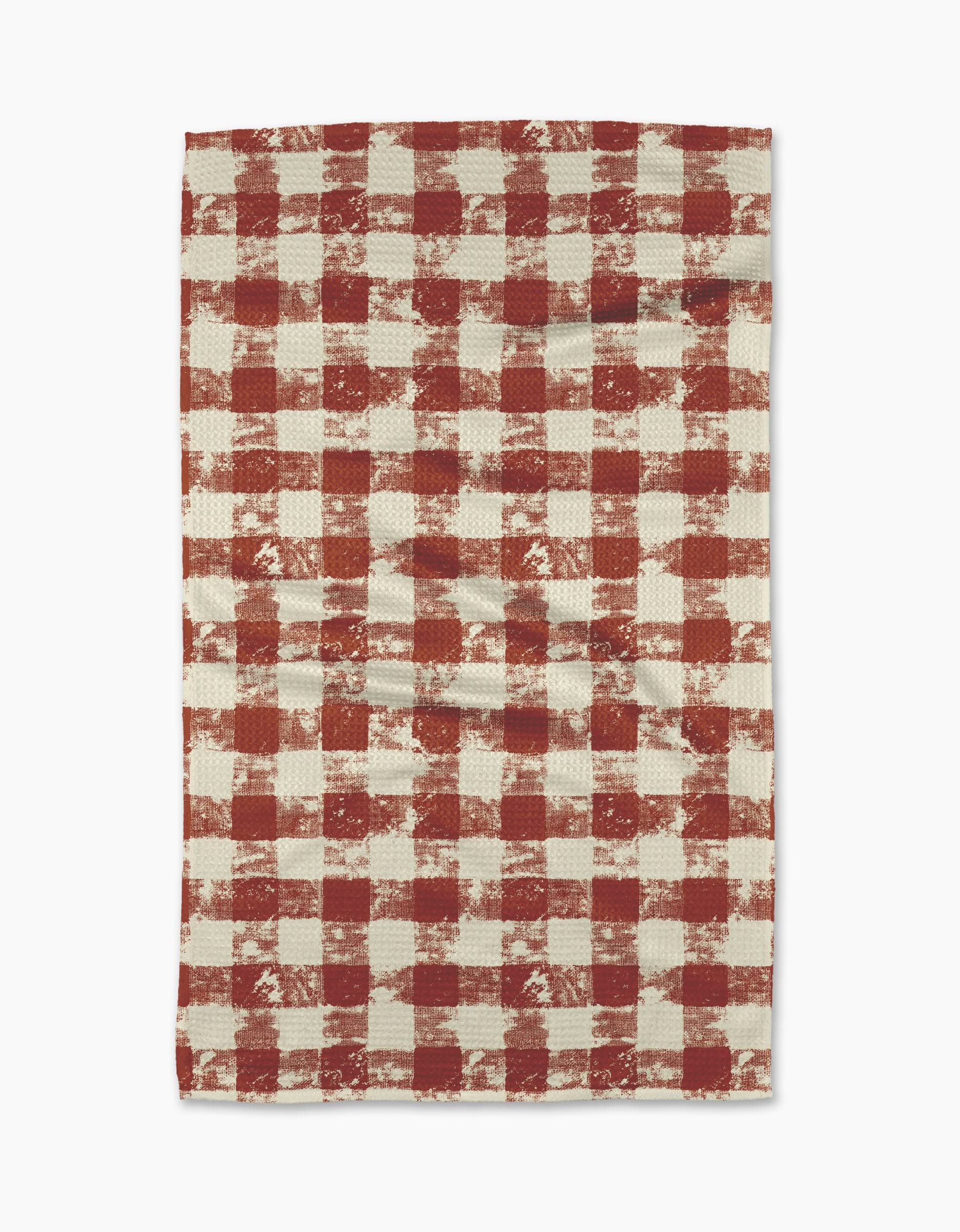 The Geometry Patch Spice tea towel features a red and white checkered pattern with a rustic, textured look. Ultra-absorbent and laid flat on a white background, its both stylish and functional for your kitchen.
