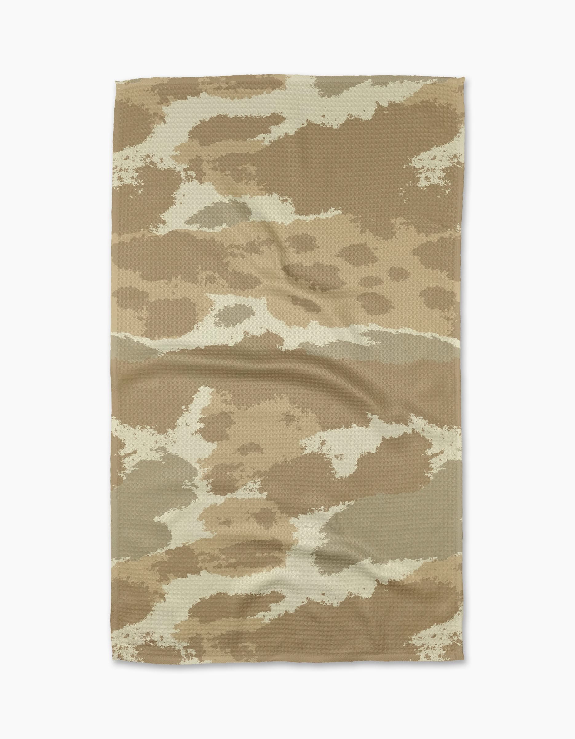 The Geometry Tarn Tan tea towel, featuring a tan and brown camouflage pattern, is laid flat on a white background. Wrinkles and fabric texture are visible.