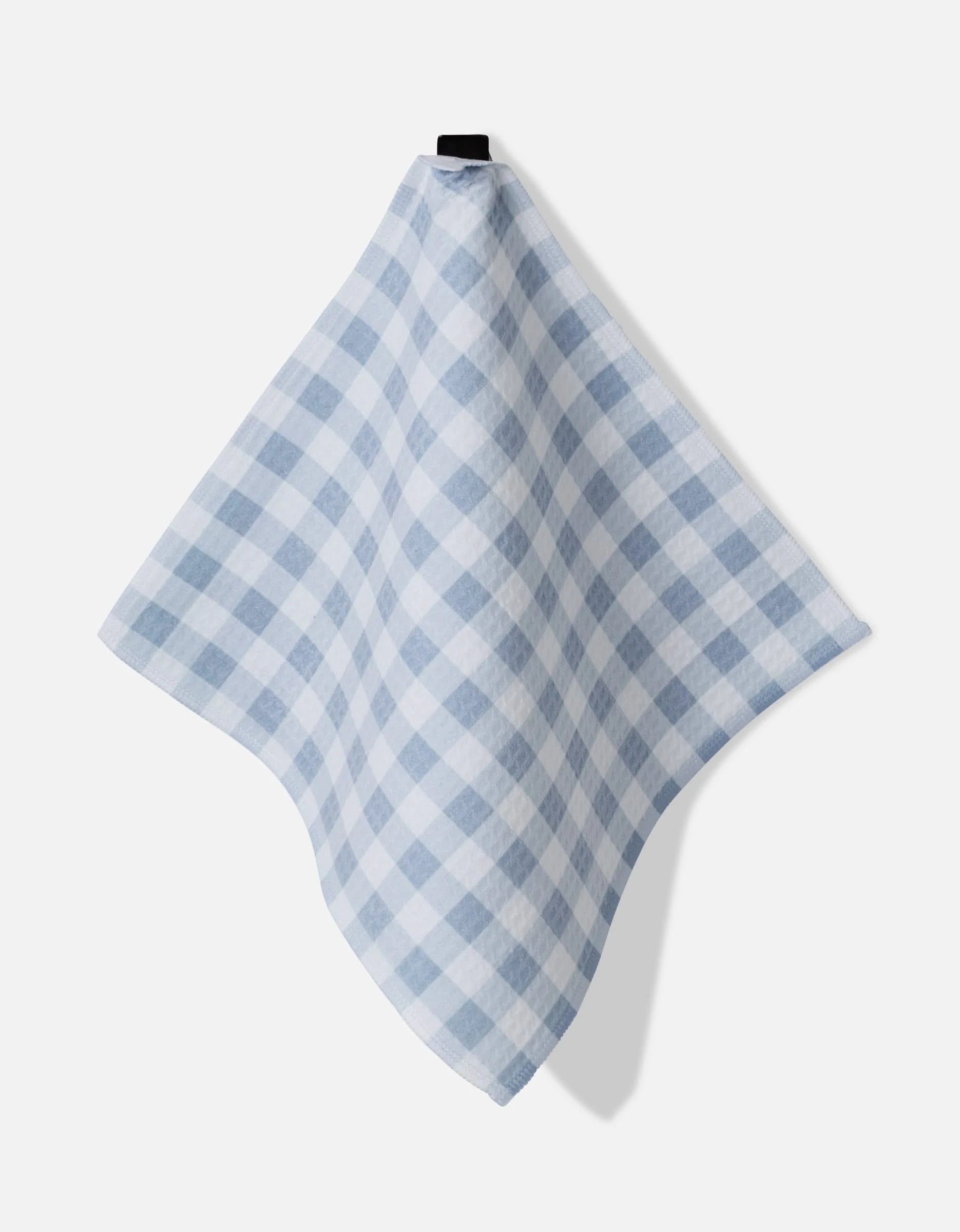 The Aubrey Fairchild Blue Gingham cloth, featuring a large blue and white checkered pattern, hangs from a black hook against a plain white background, showcasing its ultra-absorbent fabric.