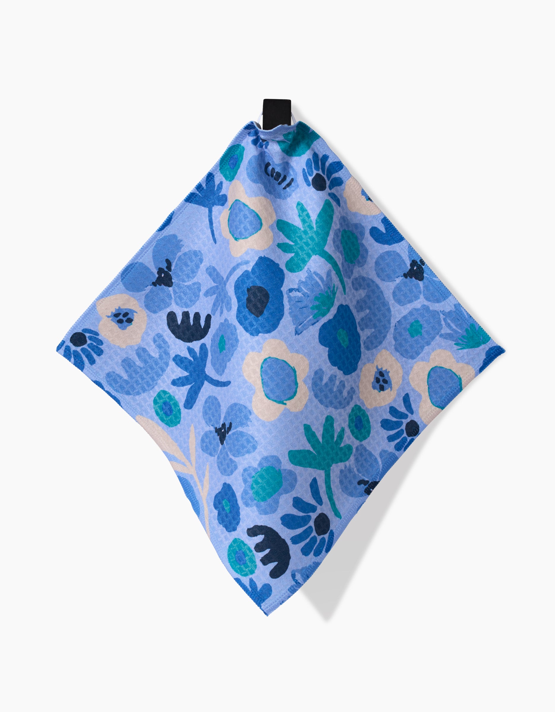 The Sareka Unique Cool Blooms napkin features blue and teal floral patterns and ultra-absorbent Geoweave technology, displayed diagonally against a white background.