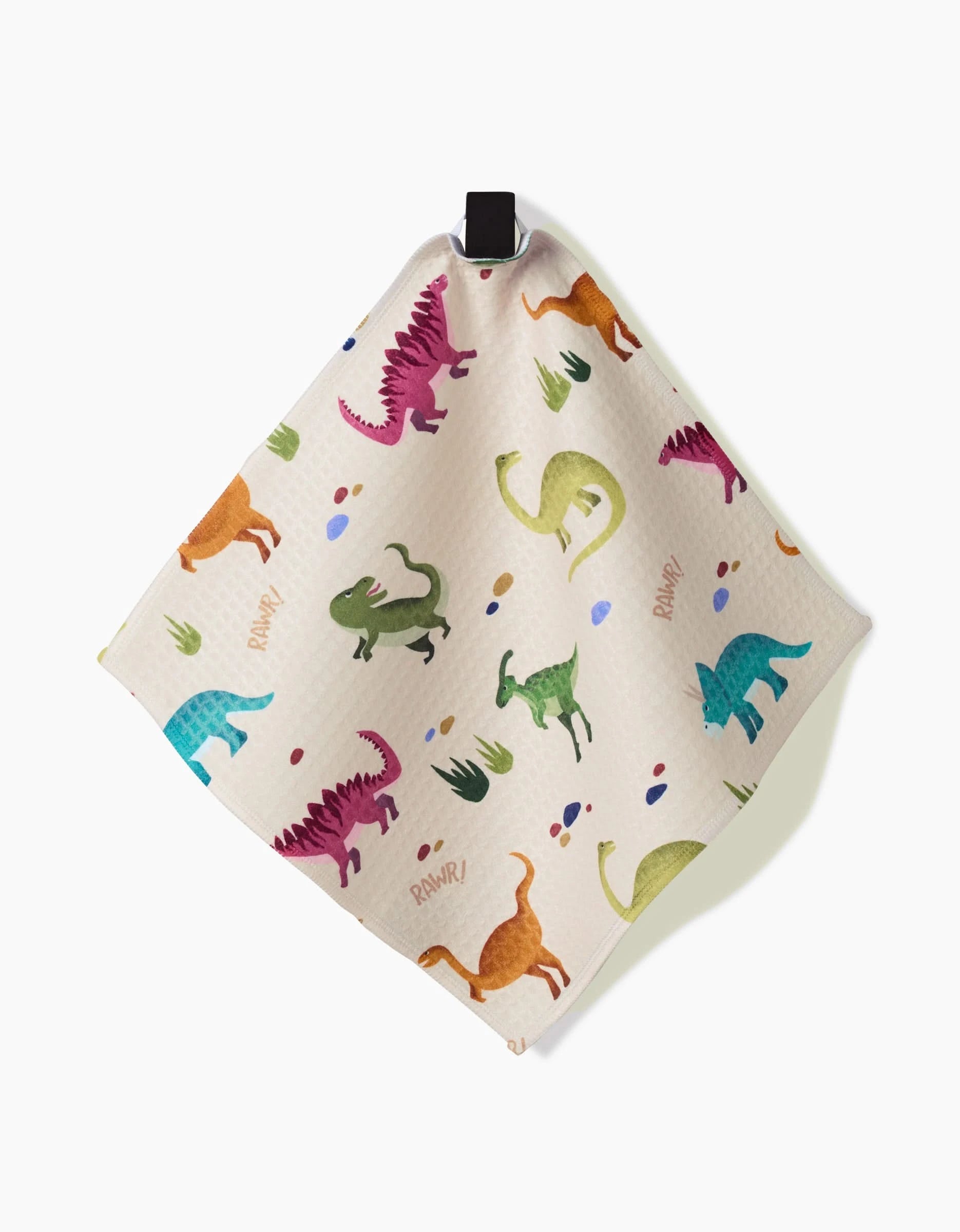 The GEOMETRY Dancing Dinos cloth features colorful cartoon dinosaurs, leaves, and RAWR! on beige fabric. It hangs by a black loop and uses ultra-absorbent Geoweave Technology for that signature Luxe Washcloths feel.