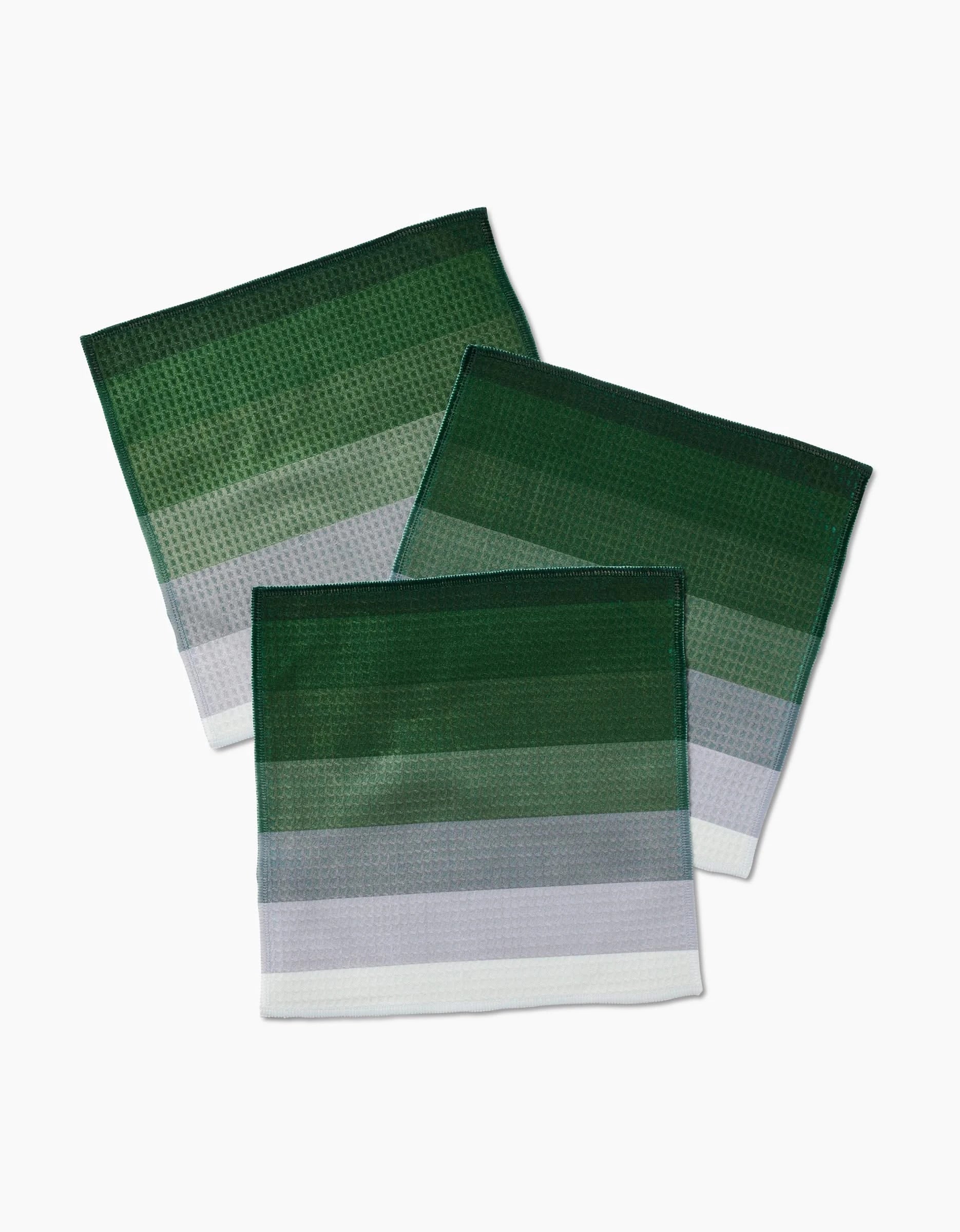 Three Grassy Levels napkins by GEOMETRY, featuring green and white stripes and Geoweave technology, are arranged overlapping on a white background.
