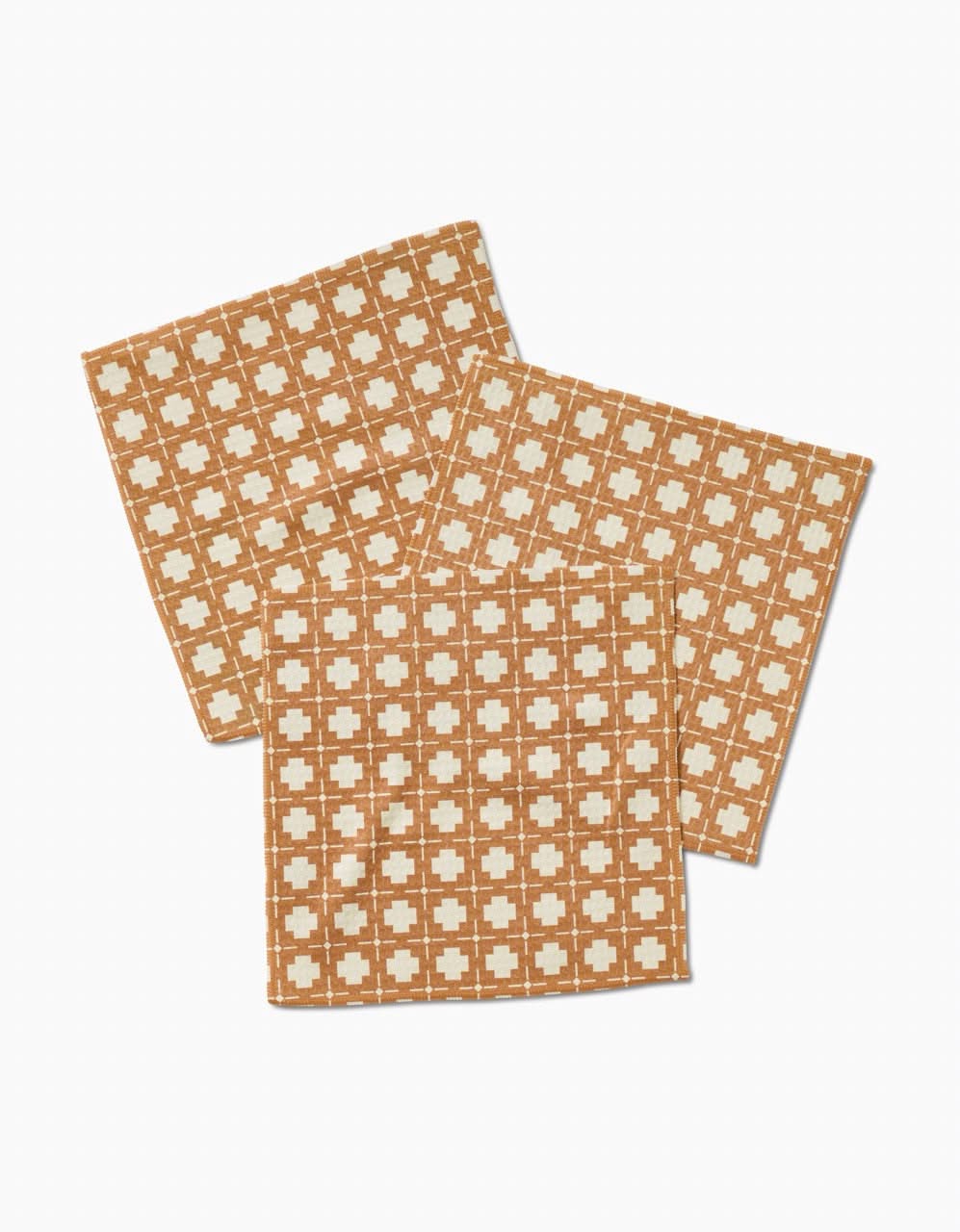 Three Jackson washcloths by Charlie Rowan Designs, made from recycled materials, display a brown and beige checkered geometric pattern of small squares and crosses, arranged overlapping on a white background.