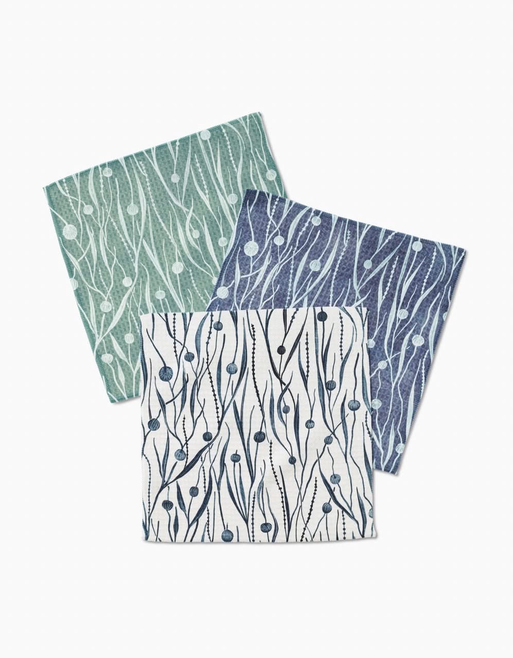 Three folded Kelp Luxe Washcloths by Katie OShea in white, blue, and green, each with an abstract botanical pattern. Crafted with ultra-absorbent Geoweave technology, they are arranged overlapping on a white background.