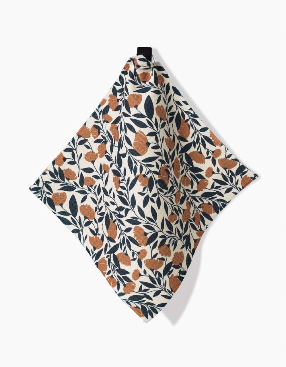 Naomi by Charlie Rowan Designs: a Luxe Washcloth crafted from recycled materials, showcasing a square botanical print with orange flowers and dark leaves on cream, hanging from a black loop against a white backdrop.