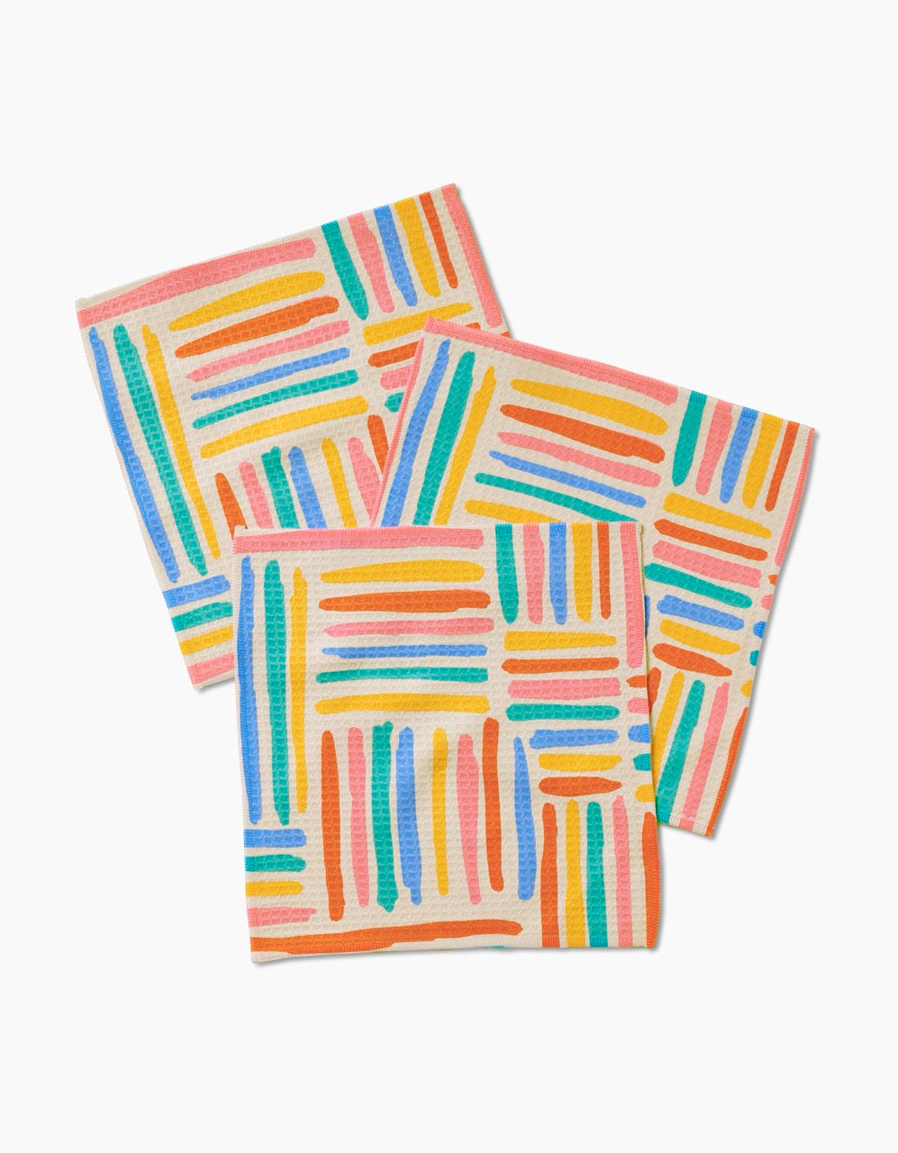 Three square Sareka Unique Pathways Luxe Washcloths, featuring colorful hand-drawn stripes in orange, blue, pink, yellow, and green, overlap on a white background. Made with Geoweave technology for ultra-absorbency.