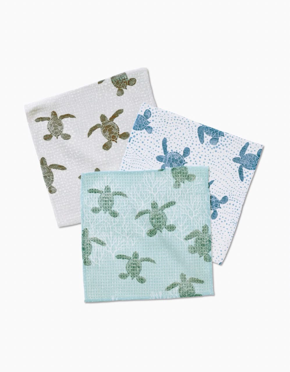 Three Katie OShea Sea Turtles Luxe Washcloths in green and blue, each with a unique turtle design and subtle backgrounds, are displayed overlapping on a white surface. Ultra-absorbent cloths combine style with function.