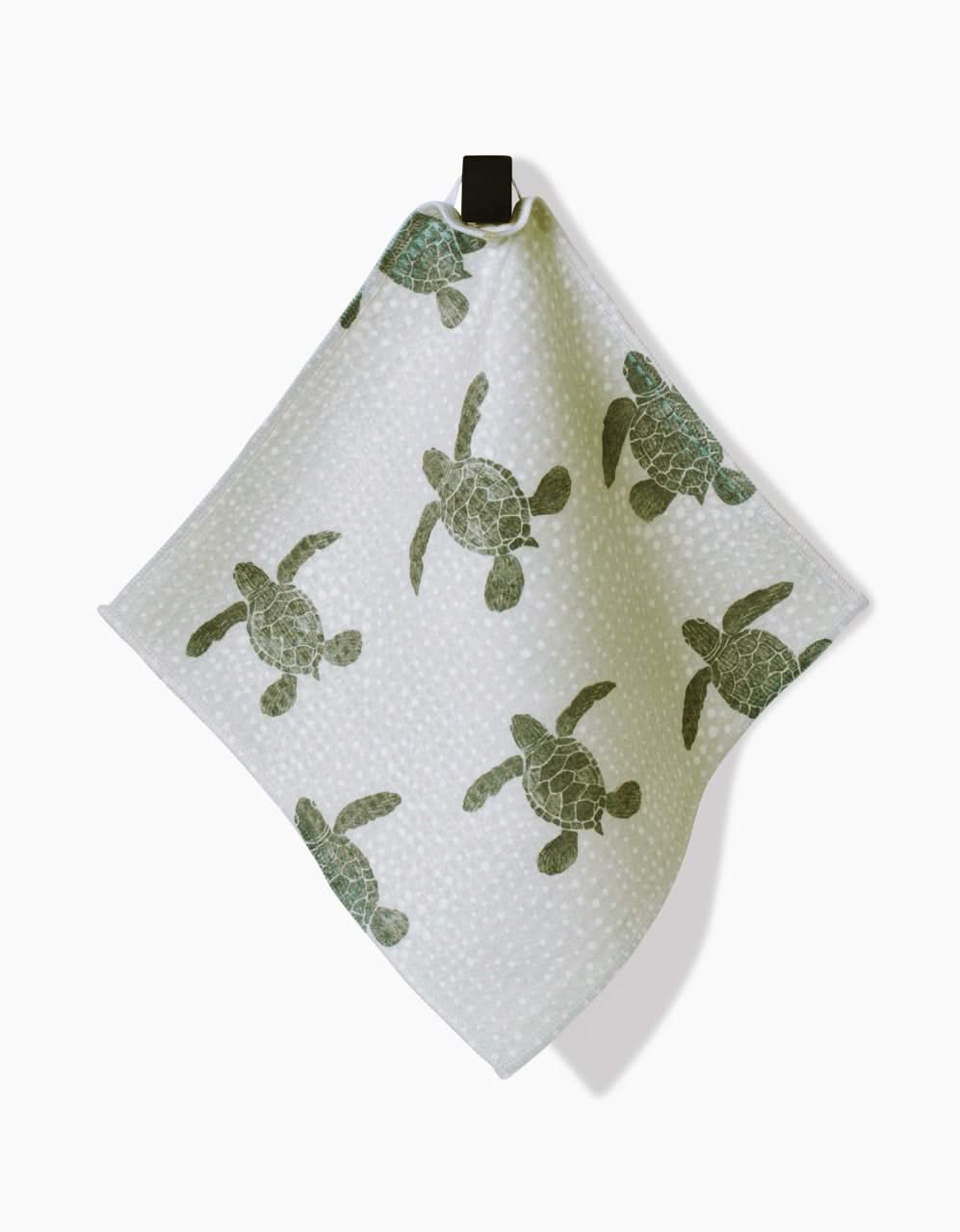 The Sea Turtles towel by Katie OShea features green sea turtles and white dots, hangs from a black loop, and is made with ultra-absorbent Geoweave technology for lasting softness and quick drying.