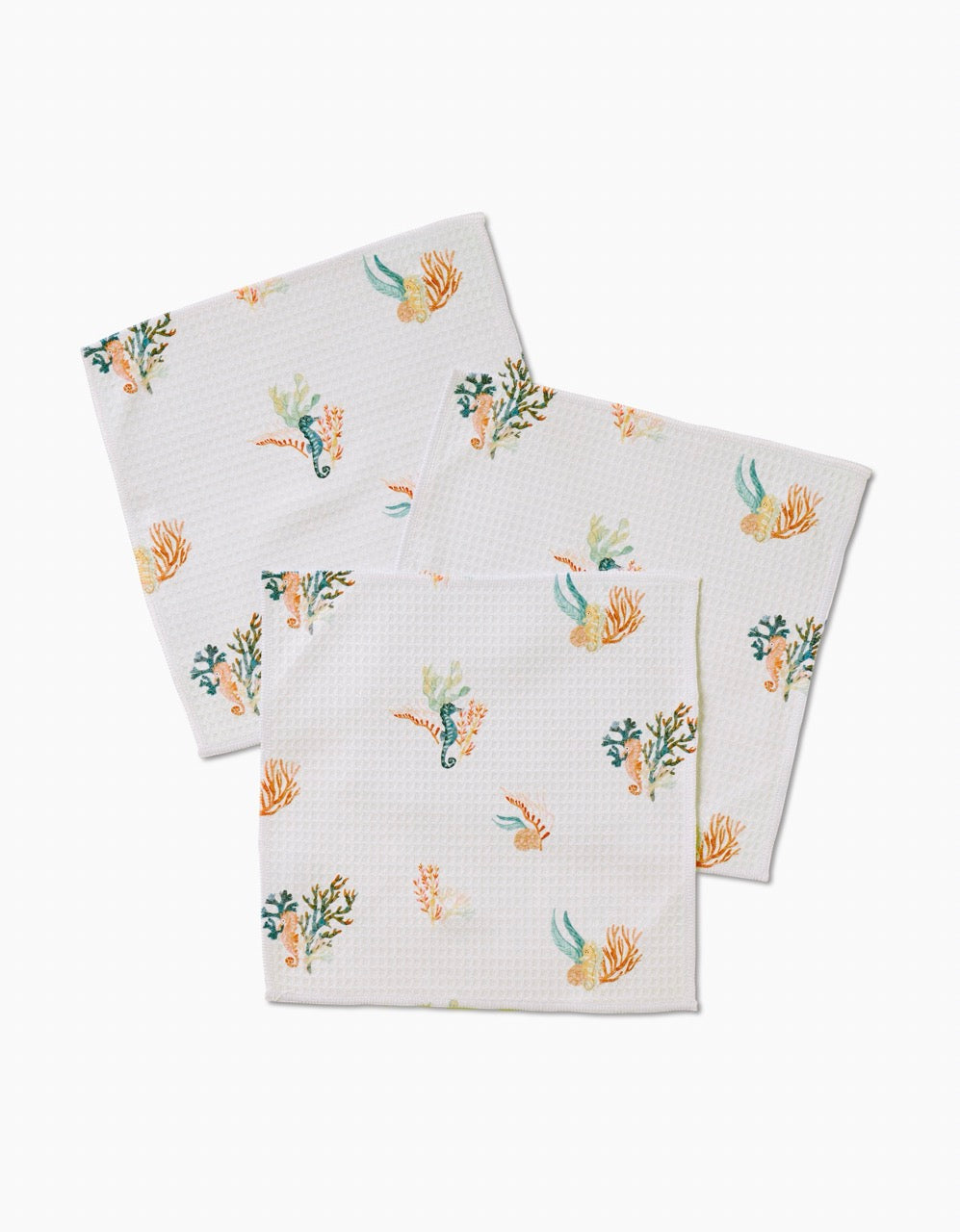 Seahorse Serendipity by Janna Sue Design: three eco-friendly white napkins with colorful seaweed, coral, and seahorse prints, crafted from recycled washcloths and displayed on a plain white background.