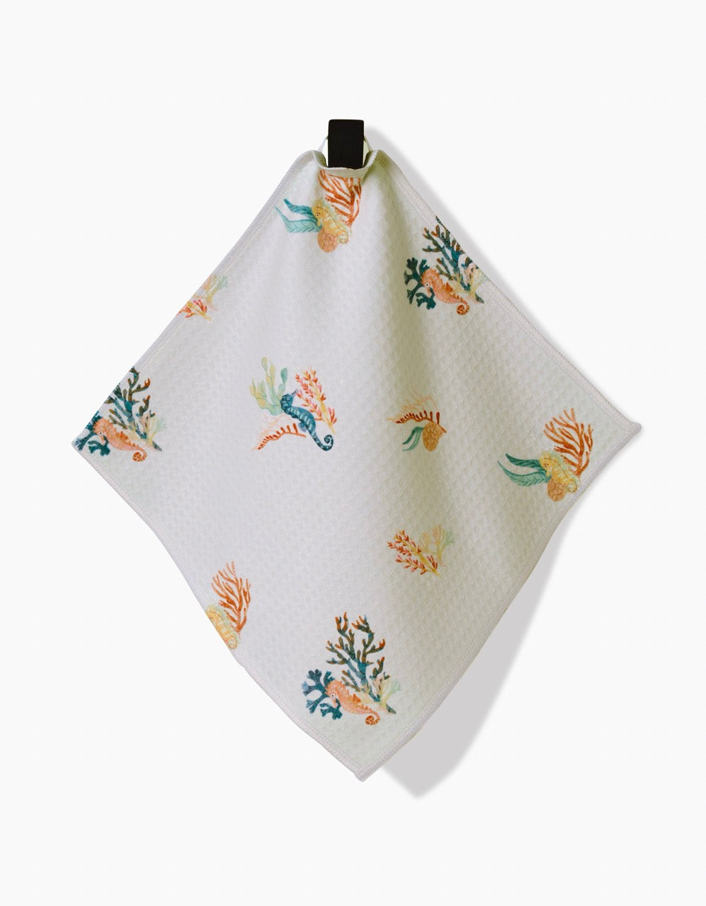 The Seahorse Serendipity washcloth by Janna Sue Design is a white, textured, ultra-absorbent cloth featuring colorful sea-themed illustrations. It hangs from a black loop against a plain white background.