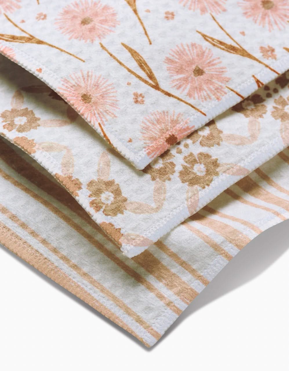 The Hufton Studio Sweet Boho set includes three Luxe Washcloths made from ultra-absorbent recycled materials, featuring pink and orange floral, beige and peach floral, and peach and cream stripe designs on a white background.