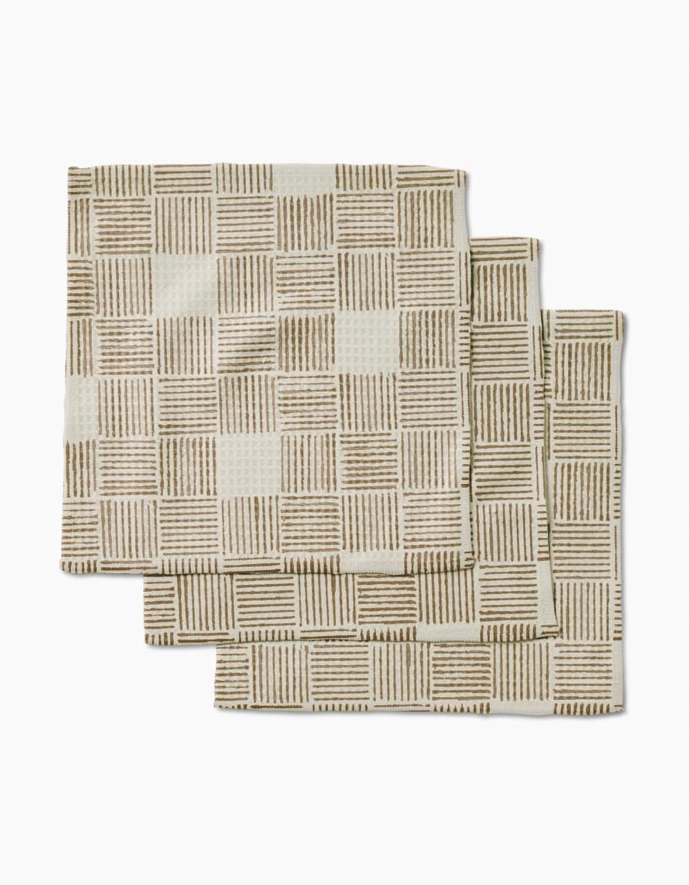 Three Thatcher napkins by Studio Jeannot are stacked on a white background, featuring a beige color and brown grid pattern. Crafted from ultra-absorbent recycled materials, theyre both stylish and eco-friendly.