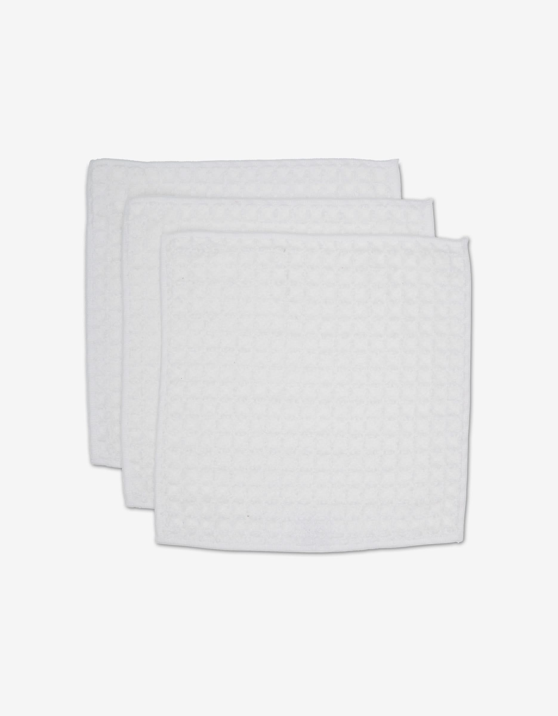 Three white, rectangular GEOMETRY Cloud waffle washcloths with a textured pattern are stacked on a white background, adding spa-like comfort and luxury to your towel collection.