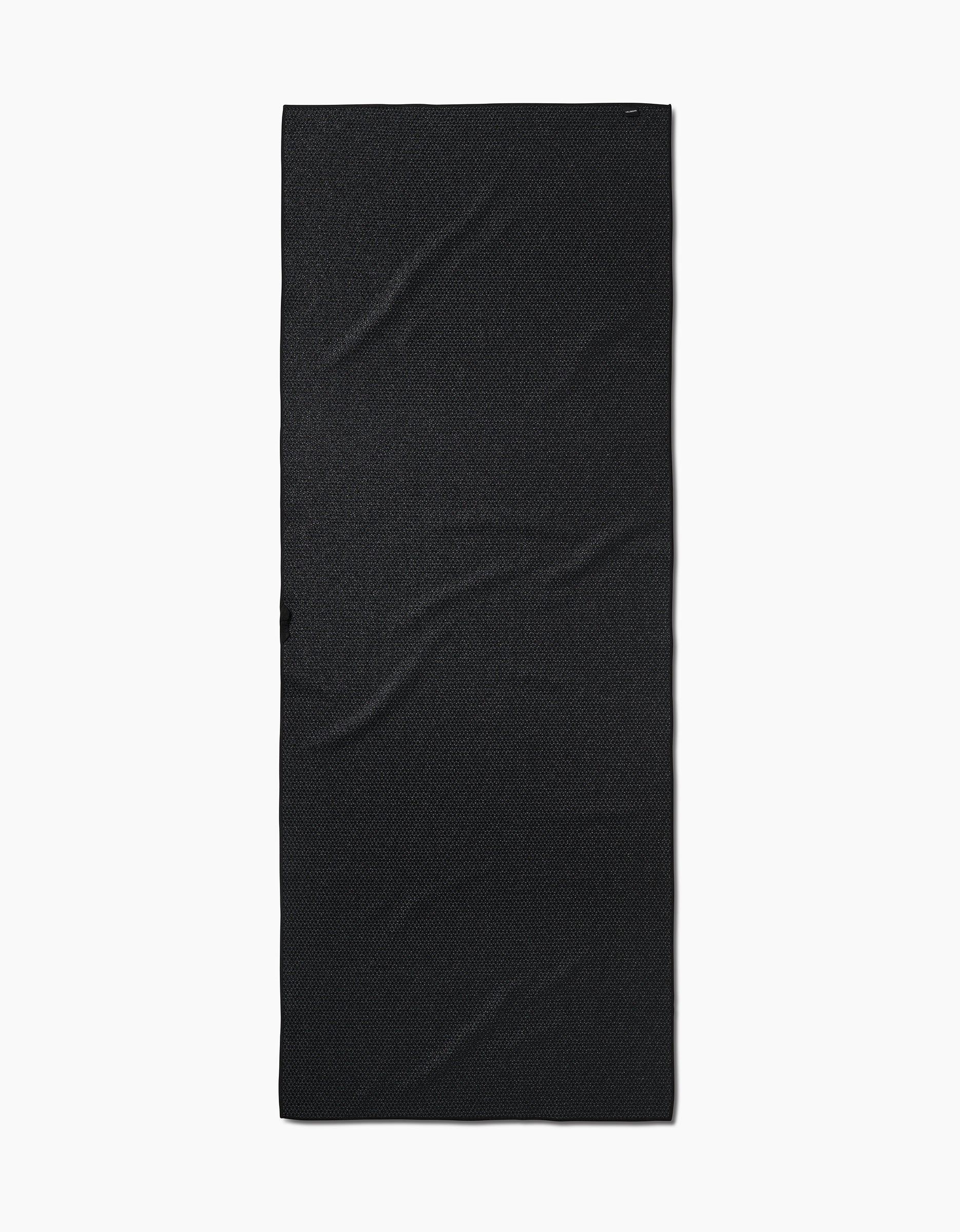 The Amy MacCready San Diego is a plain, rectangular black yoga towel made from recycled materials for an eco-friendly touch, shown laid flat on a white background with subtle wrinkles and texture.