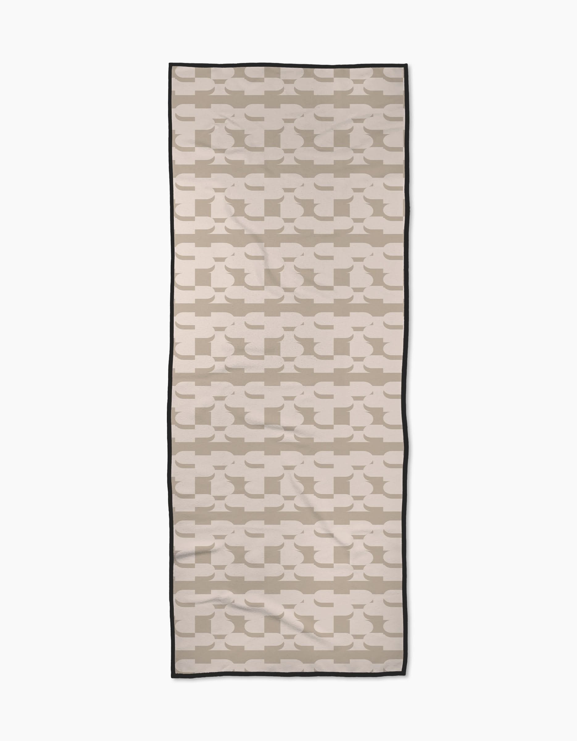 Buttons by Geometry is a rectangular yoga towel with an overlapping beige and taupe geometric pattern on cream, bordered by a thin black edge. Made from recycled materials for an eco-friendly and mindful practice.